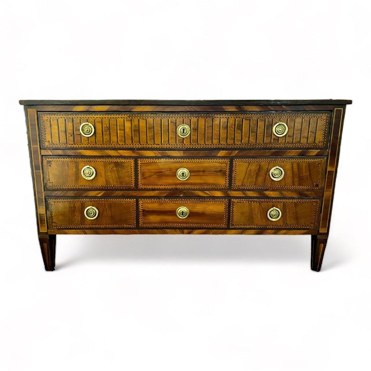 We are delighted to present you with this wonderful Italian chest of drawers originating from the Louis XVI period. Its top displays stunning marquetry that enhances its aesthetic appeal by adding more detailing to its overall design. The piece