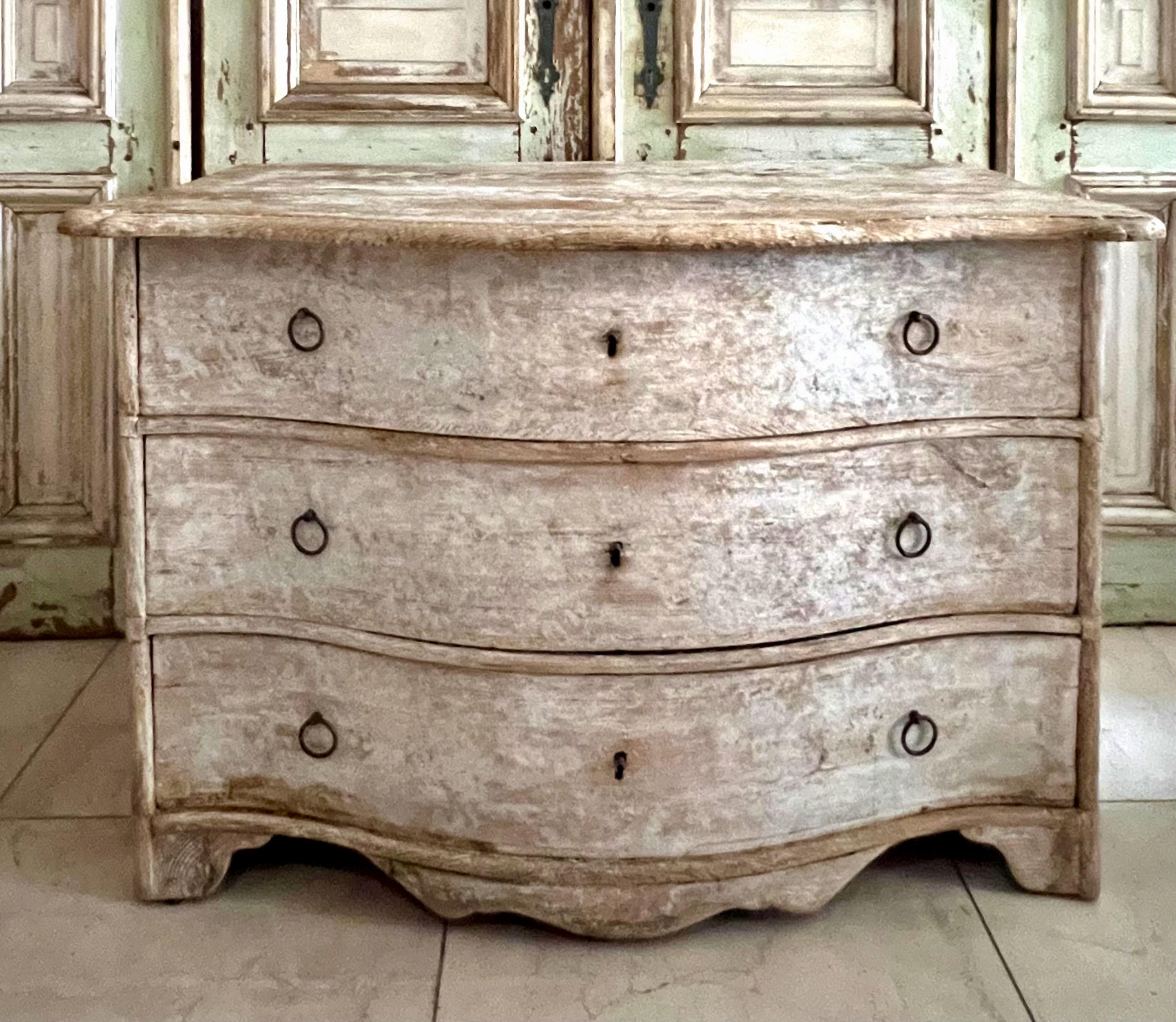 18th century chest of drawers from late Baroque period in richly carved curvaceous serpentine drawer fronts, shaped top and bracket feet in super worn patina.
Alsace, France.