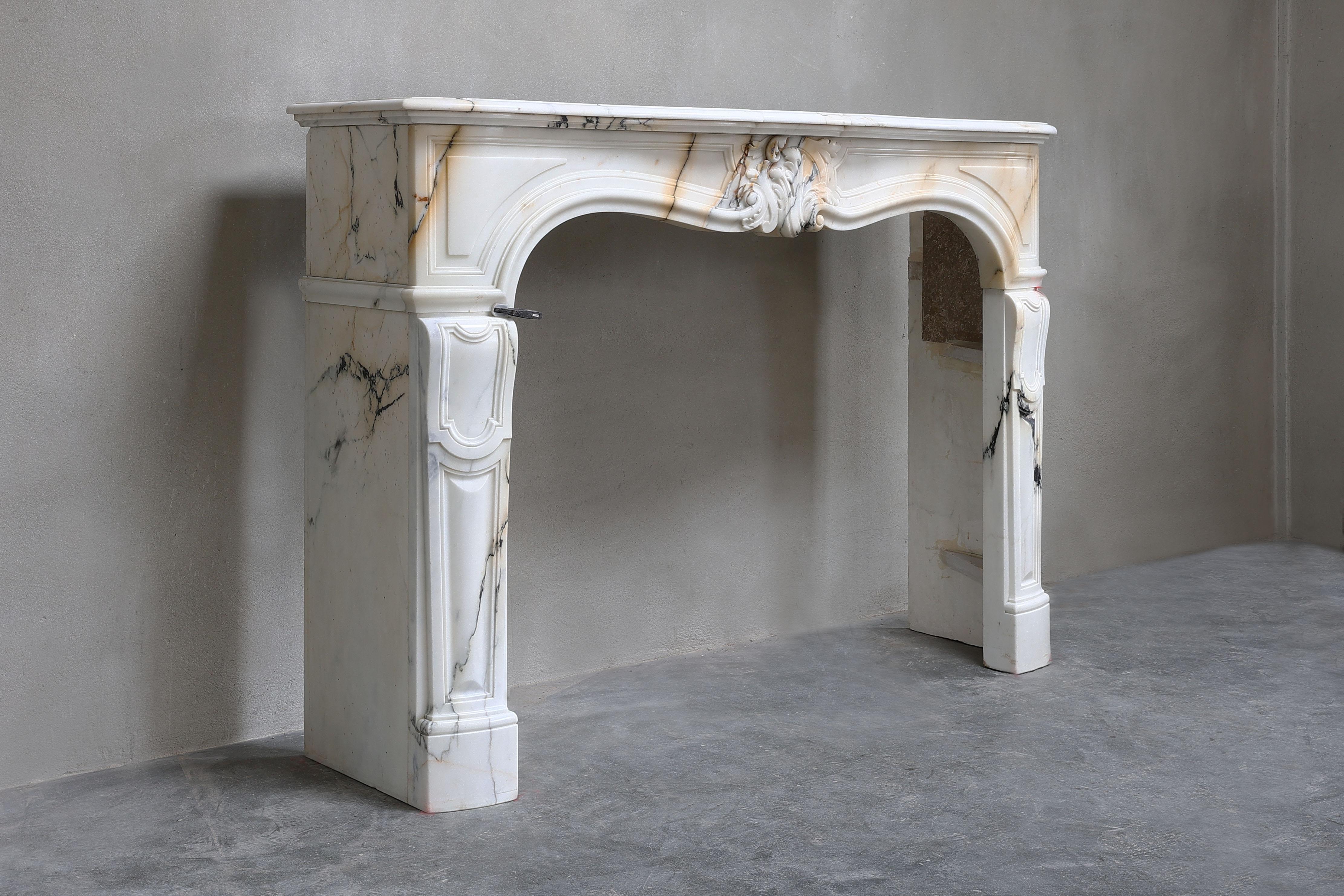 Very beautiful antique fireplace of the rare marble Paonazzo from Italy. This fireplace has a warm color scheme, beautiful veins and beautiful round shapes. The fireplace is in Louis XV style and has an asymmetrical scallop in the center. The origin