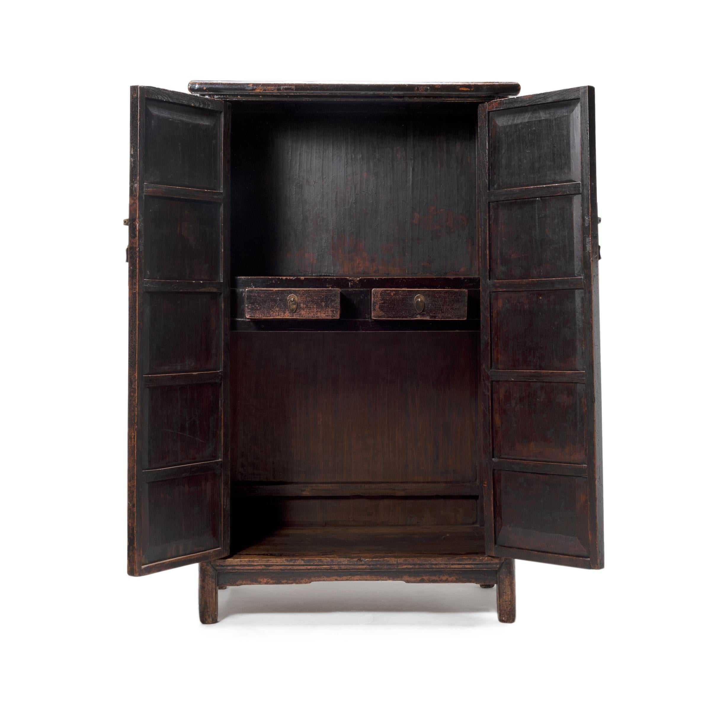 The essence of traditional Chinese furniture is fully expressed in the simplicity and graceful presence of this 18th century two-door cabinet. Crafted of southern elmwood with traditional joinery techniques, the tall cabinet is gently tapered, with