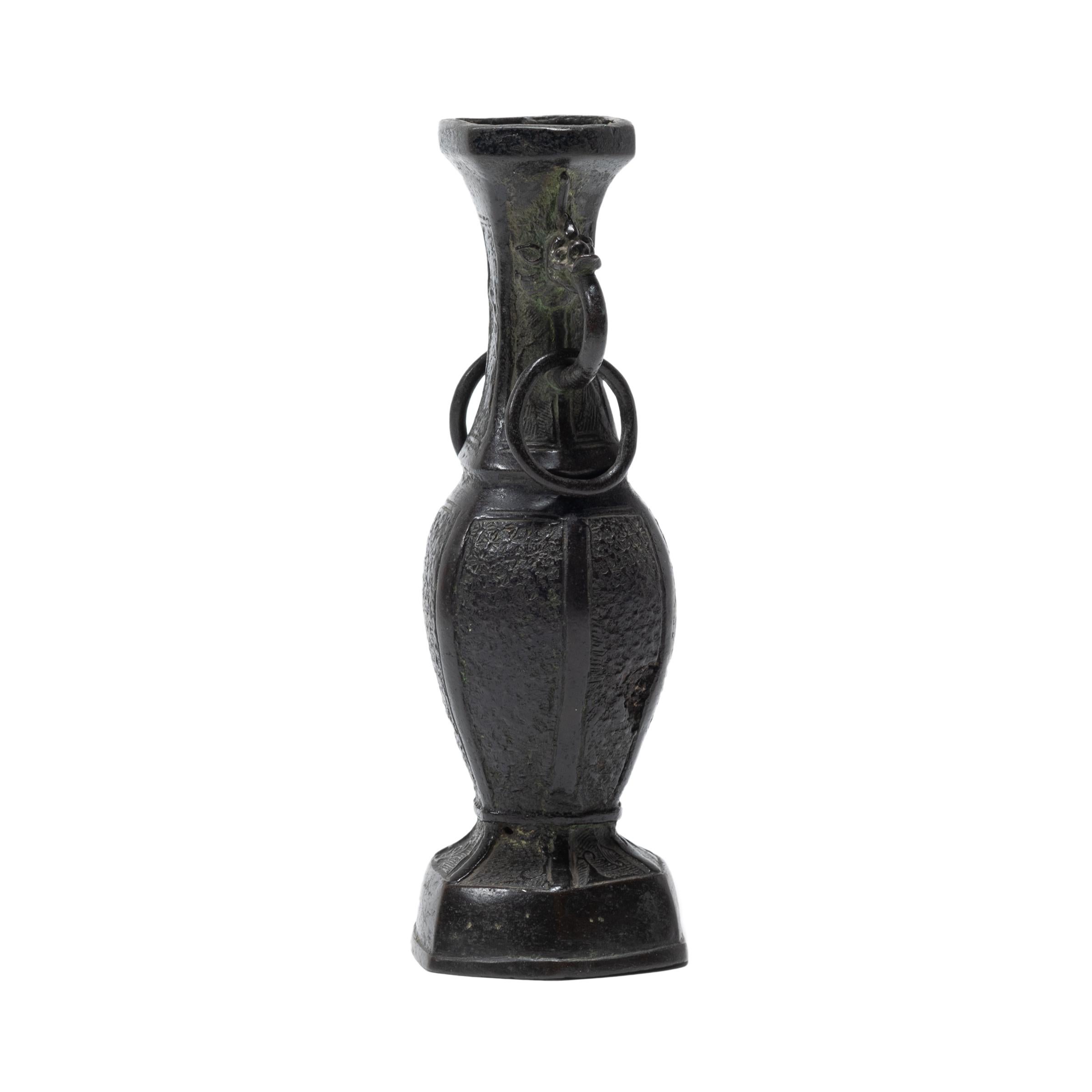 This early 18th century bronze vase is reminiscent of the ritual bronzes used by China’s earliest rulers. Reinterpreting a traditional bronze form, this petite six-sided vessel was cast with a rotund, tapered form set atop a footed base. An