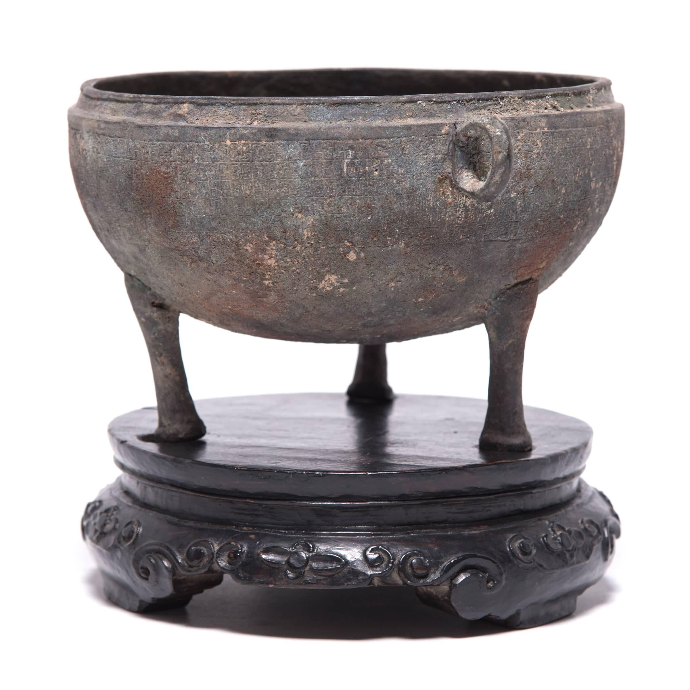 This 18th century bronze vessel with tripod feet was crafted by hand in a traditional Chinese shape known as 
