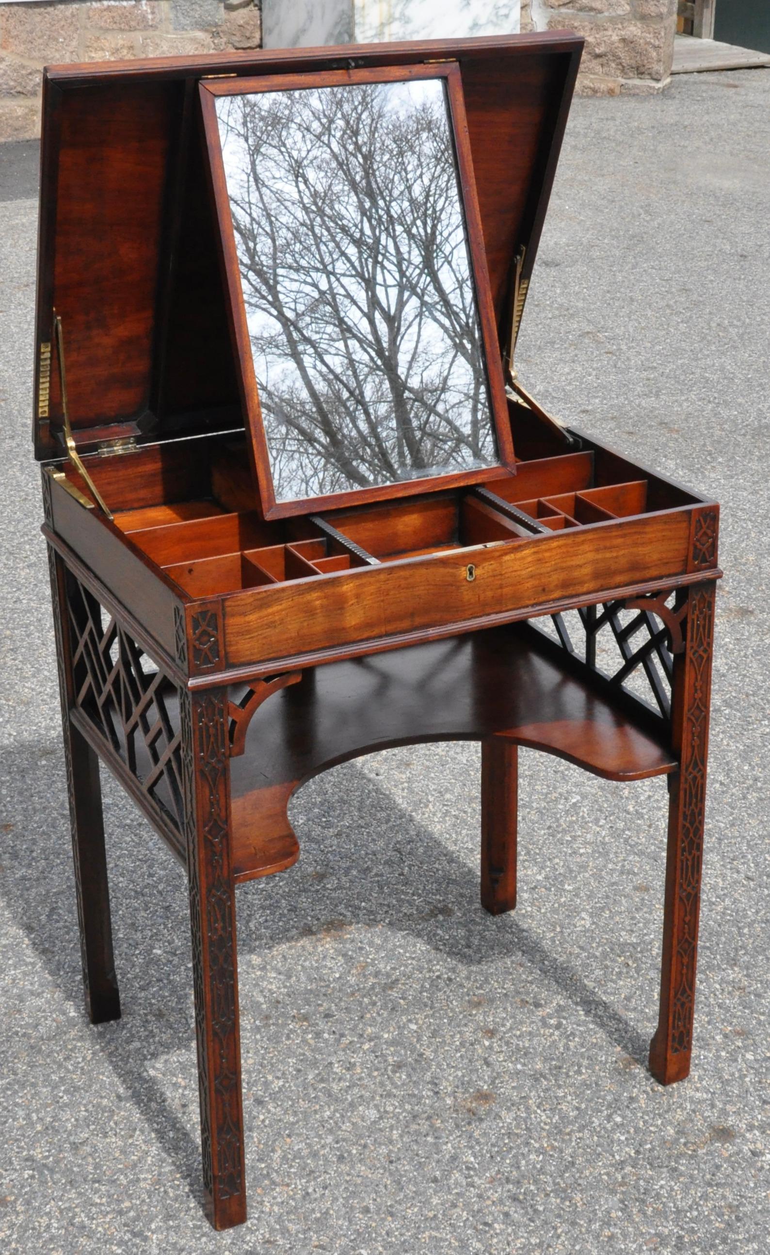 George III 18th century English Chinese Chippendale mahogany side table. Fretwork and carved chinoiserie legs. Top opens to reveal a padouk interior fitted for dressing.

Truly a collector's piece.