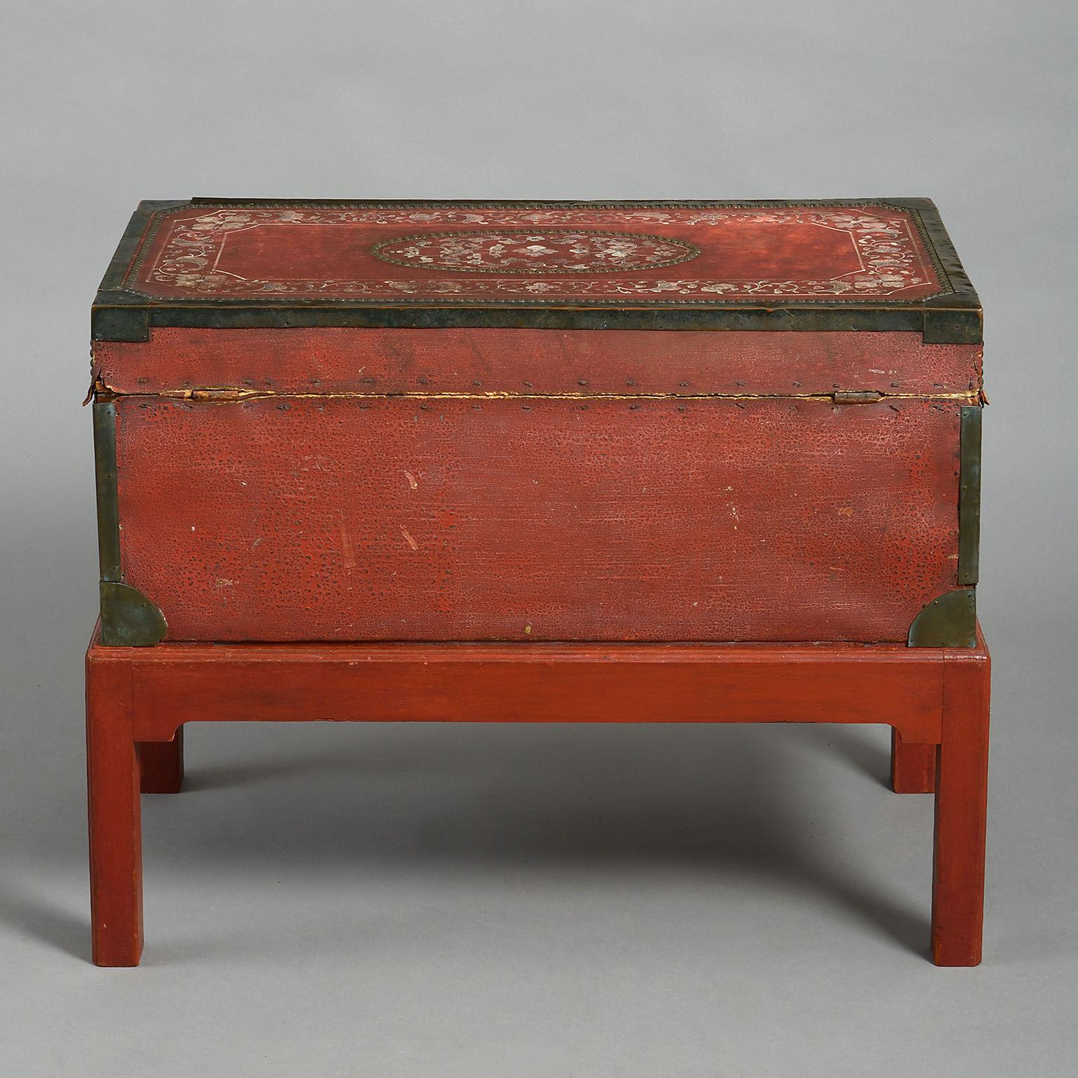 Camphor-lined and with brass borders and nailing, painted with floral panels and borders on a sealing-wax red ground; on a later conforming, red-painted stand.
 