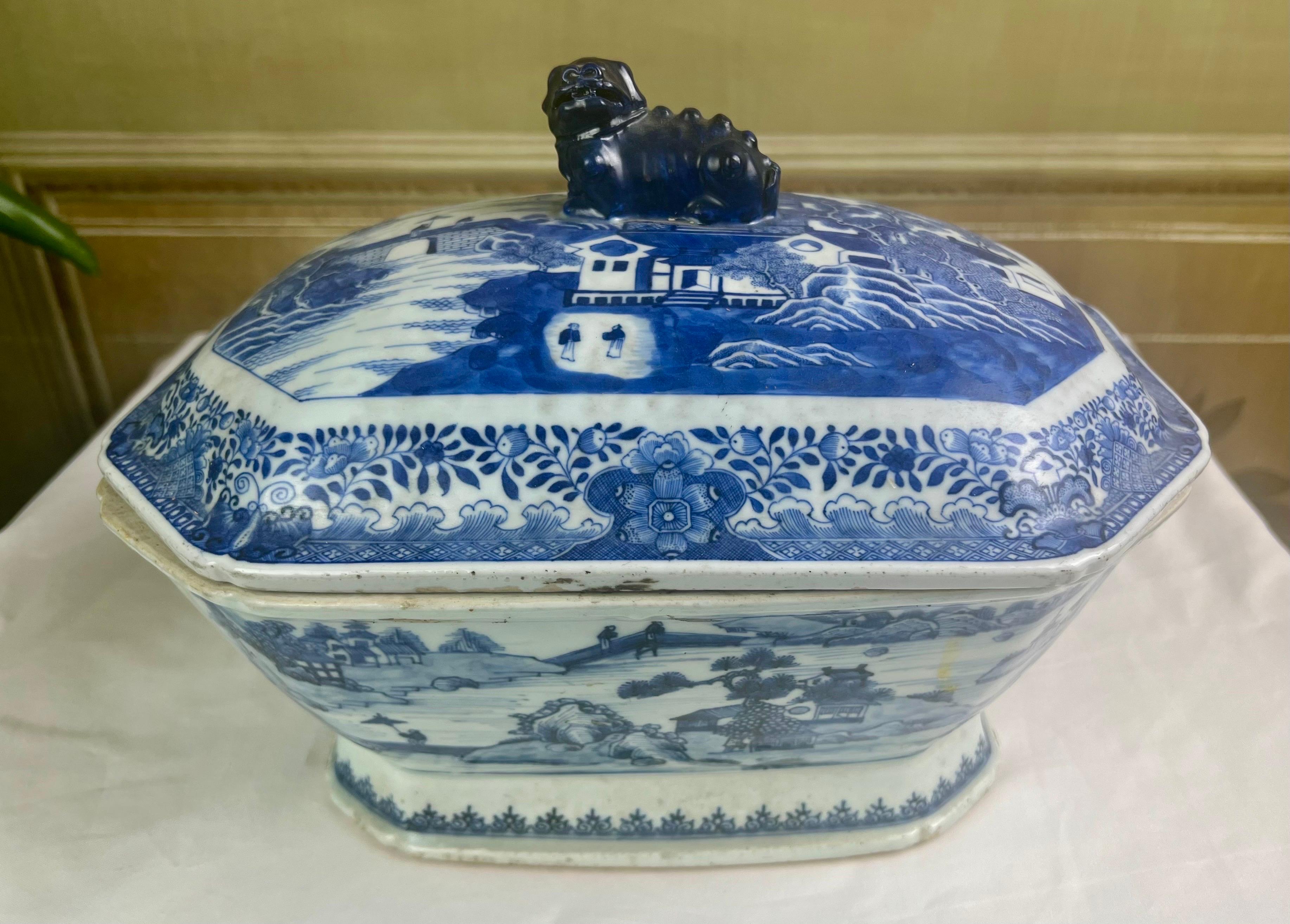 Gorgeous 18th C. under-glazed soup tureen with a dragon cover handle on the cover and wild boar handles on either side of the base piece. The piece is covered with a hand painted village scene including people, boats, willows etc. The tureen is
