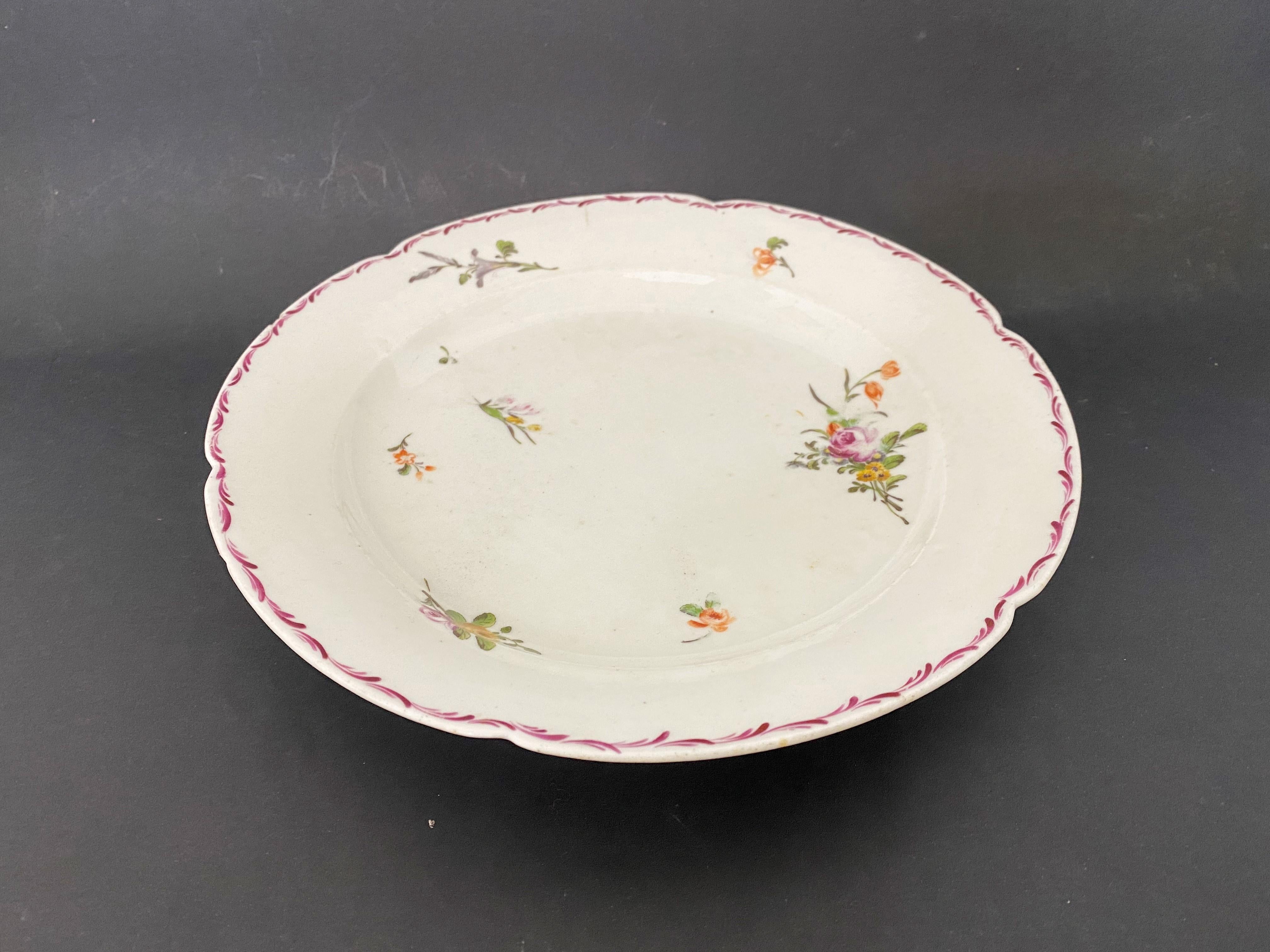 Beautiful plate of the Compagnie des Indes from the Qianlong period, 18th century. This porcelain soup plate, has very beautiful hand painted decorations, representing yellow and pink roses, buds and various plants. The contour of the plate is