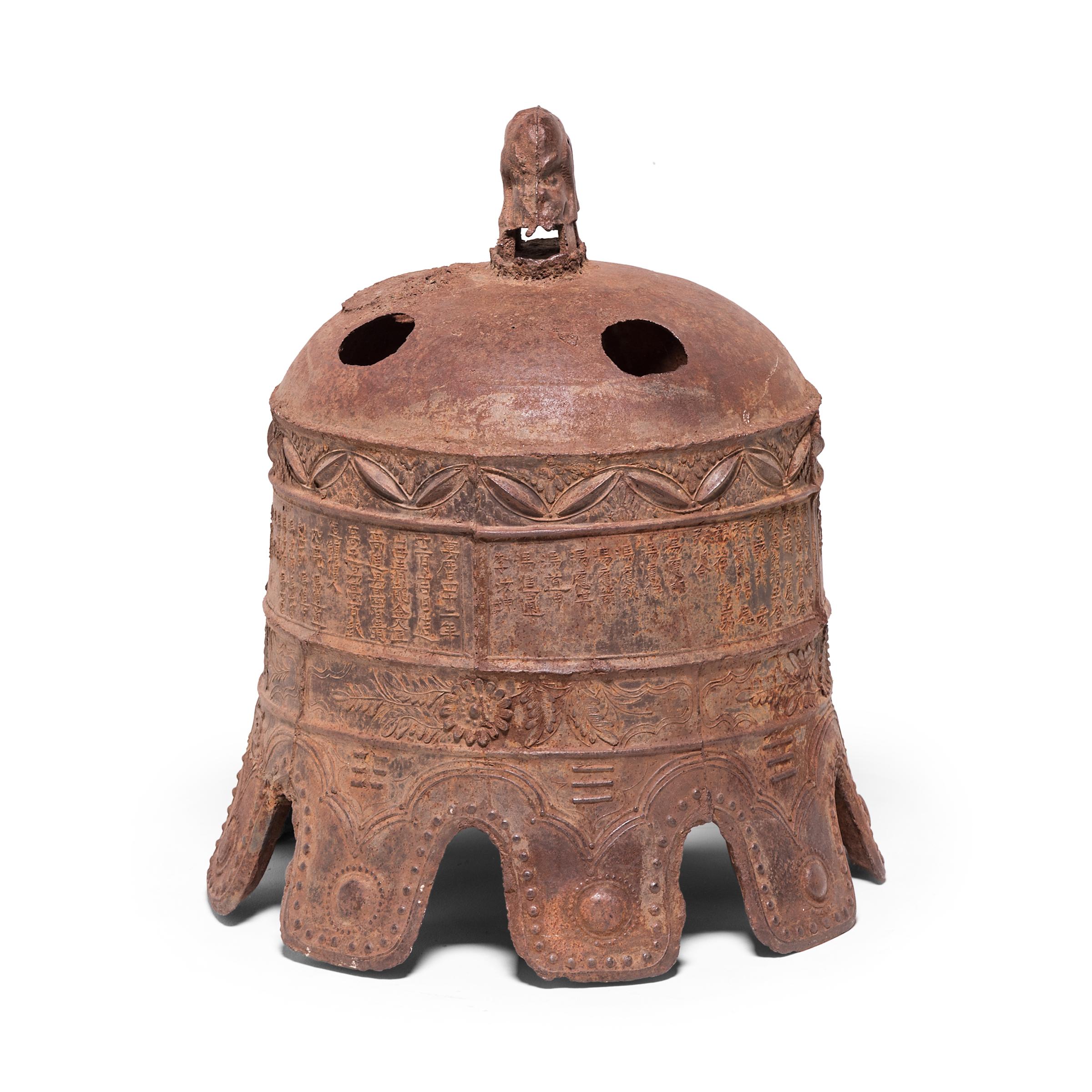 A cast iron bell, when struck with a wooden beam, announced the time of day to villagers. This monumental example is covered in relief casts of chrysanthemum blossoms and characters explaining that the piece was cast in 1613, the 42nd year of the