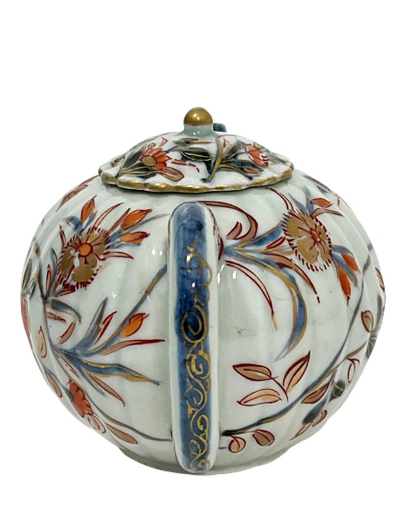 18th century Chinese Imari pumpkin shaped small teapot 

A small Chinese Imari teapot in the shape of a pumpkin in the colors of red, blue and gold (dark and light)
painted on bluish glaze with lid 

