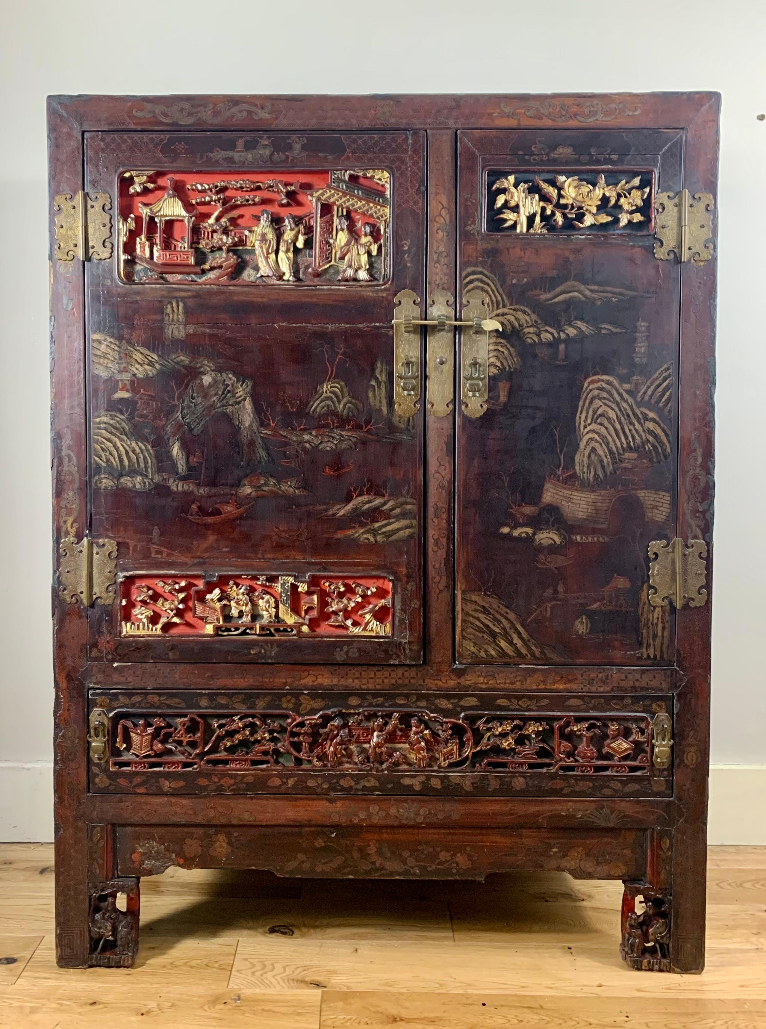 An 18th century Chinese lacquered and intricately carved and hand painted cabinet of small proportions  . 

A beautiful all over patina and aged surface , the entirety of the cabinet is painstakingly decorated with landscape , coastal scenes ,