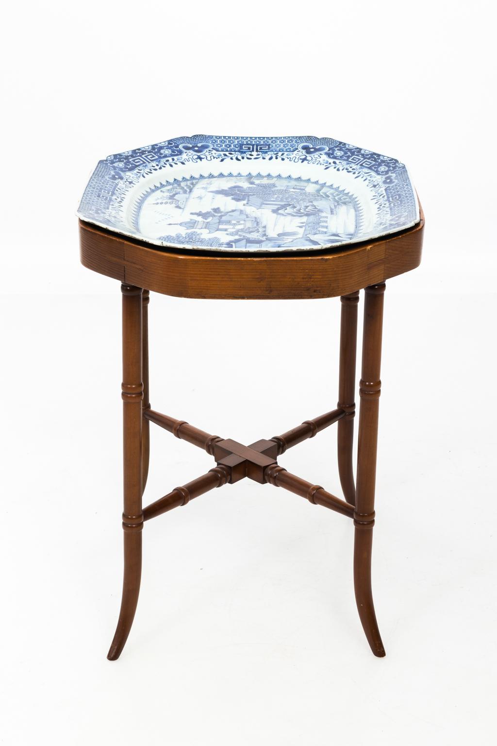 Blaue und weiße chinesische Porzellanplatte auf einem hölzernen Tabletttisch aus späterer Zeit:: ca. 18. Auf dem Porzellan ist eine chinesische Landschaftsszene abgebildet:: während der Sockel mit einem Kreuz aus Bambusimitat versehen ist. Bitte