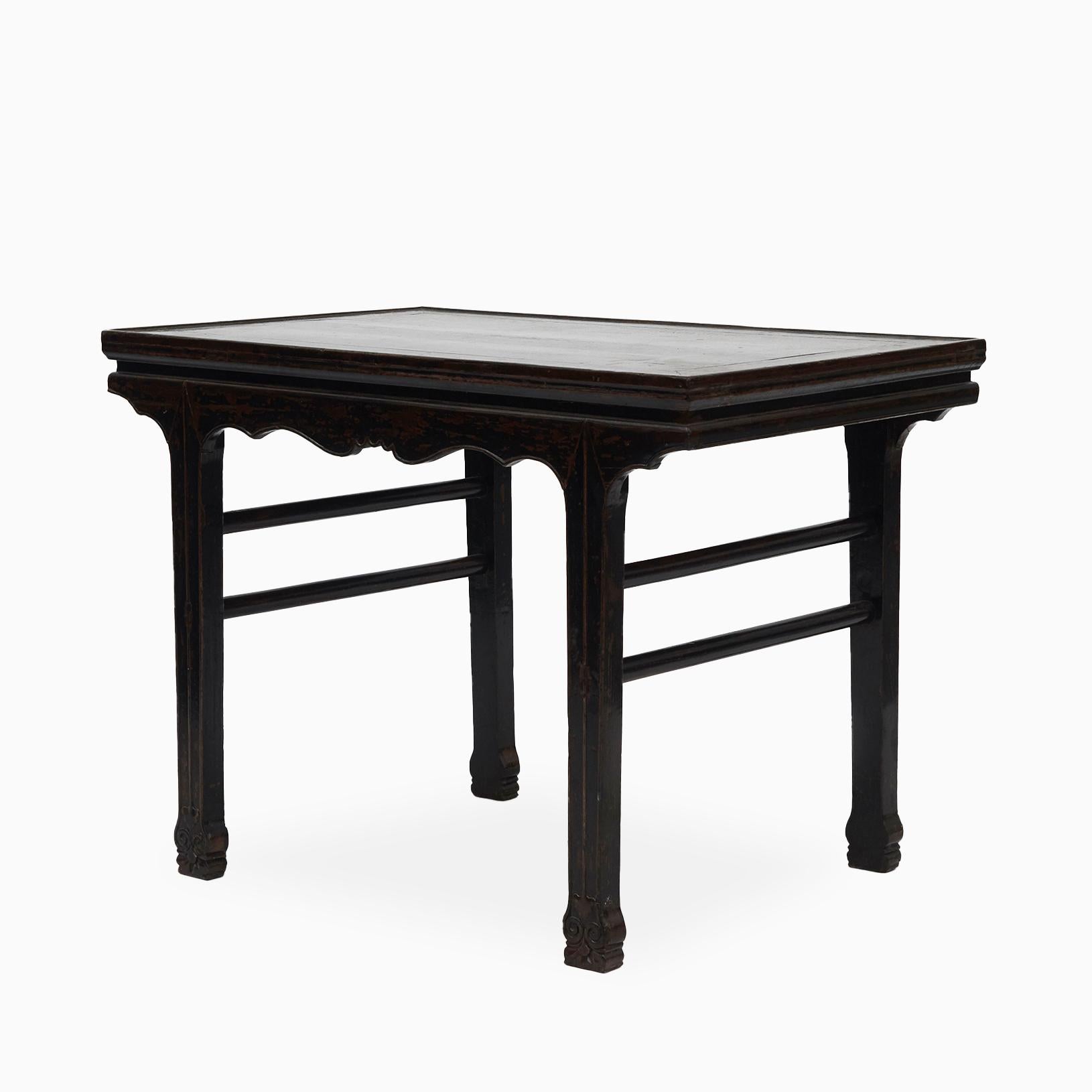 Antique 18th century Chinese wine table in black lacquer.
Tabletop with black lacquered canvas sitting above an elegant apron accented with carved spandrels. The tabletop is covered with canvas, as the original thick black lacquer only would fasten
