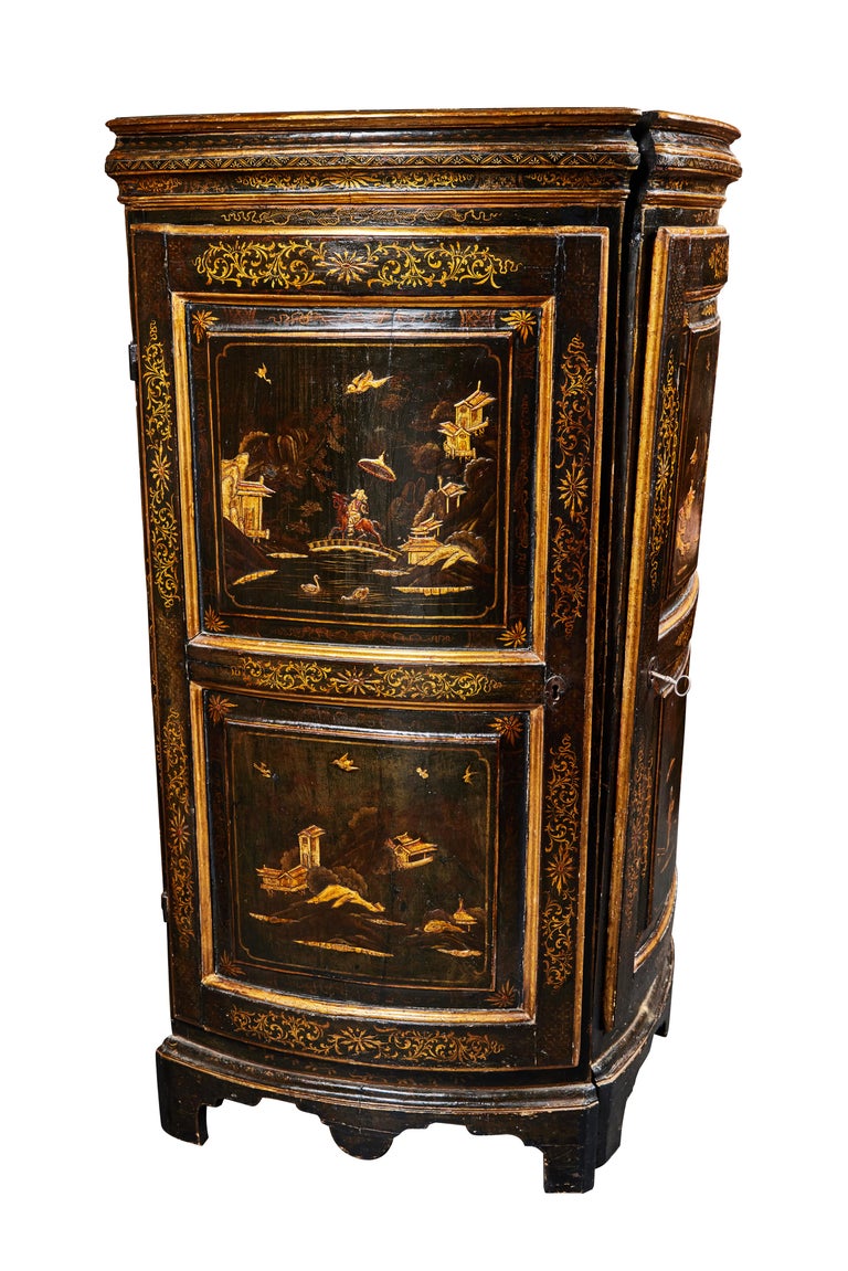 A pair of elegant, hand painted, ebonized, parcel-gilt, Italian chinoiserie corner cabinets. Each of them with doors featuring two panels painted with unique scenes. Each embellished with foliate and floral details throughout.