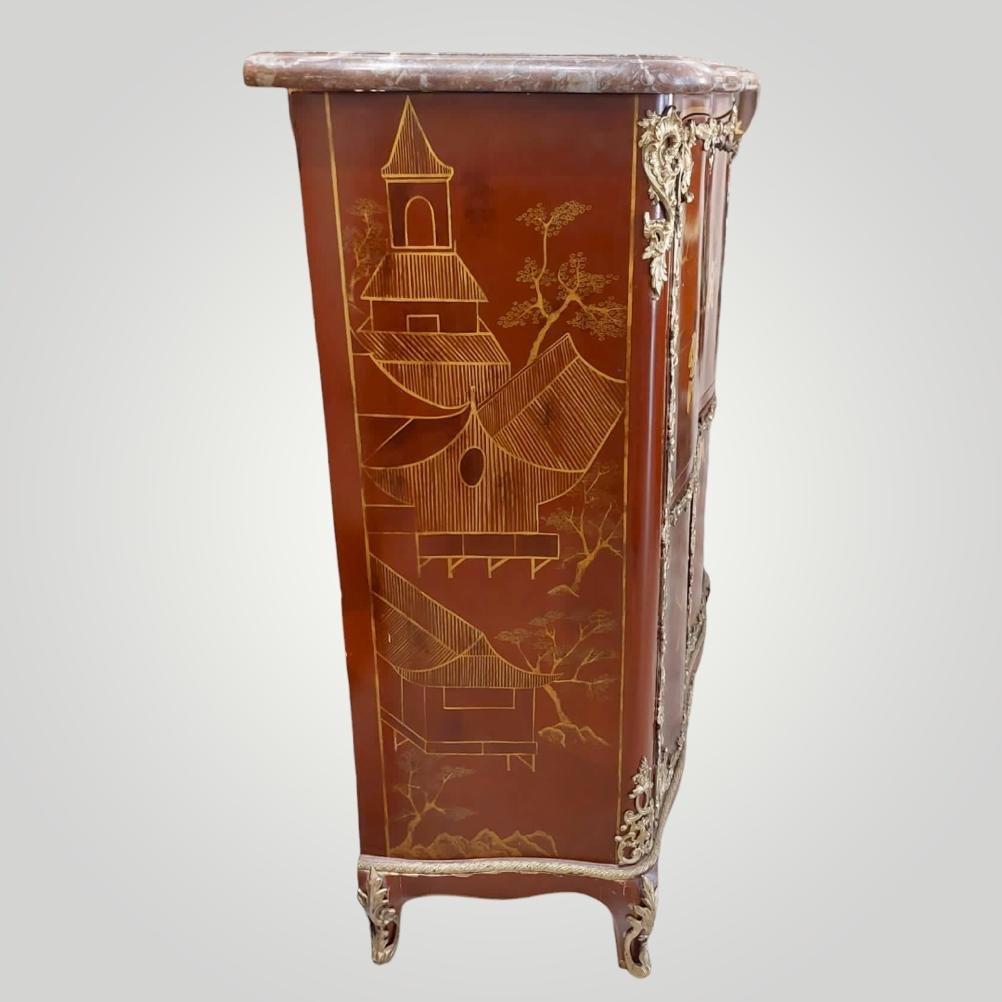 A brown-red low secretary in lacquer adorned with chinoiserie motifs by the great French cabinetmaker Jacques Dubois (1694-1763). This exquisite piece of furniture features a single flap and two doors for access. The desk's surface and the pull tab