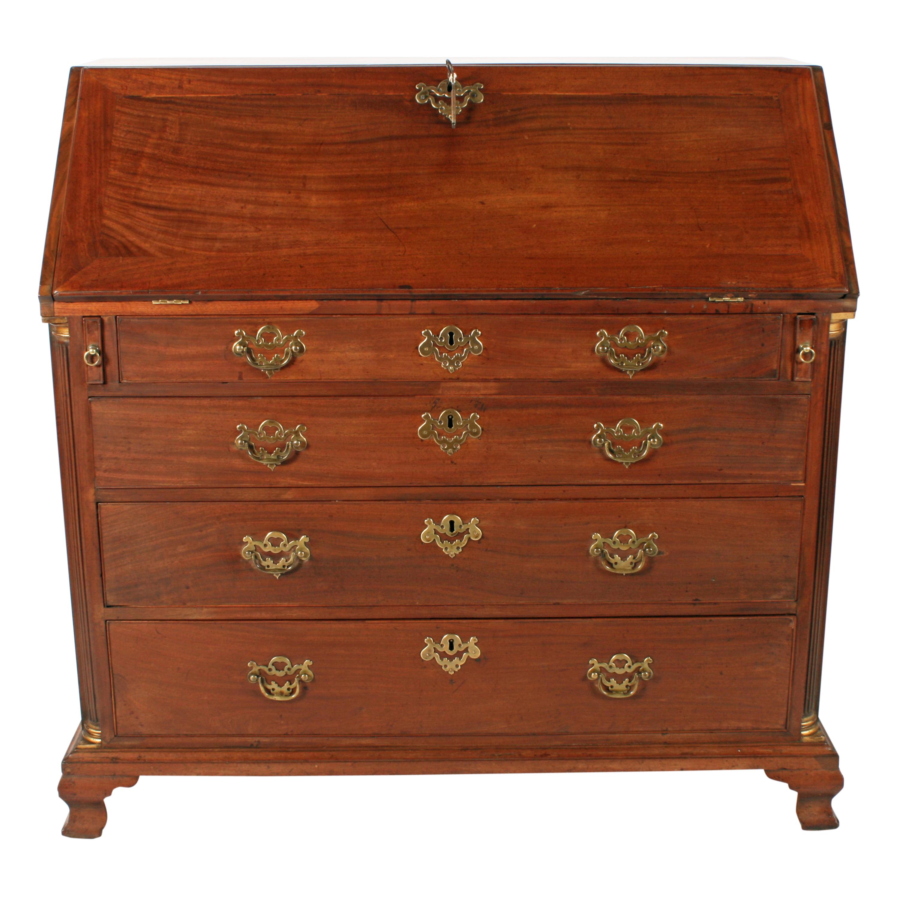 A very good example of an 18th century Chippendale mahogany bureau.

The bureau has four graduated oak lined drawers with cock beaded edges and brass handles.

Either side of the drawers is a reeded quarter column with giltwood tops and bottoms