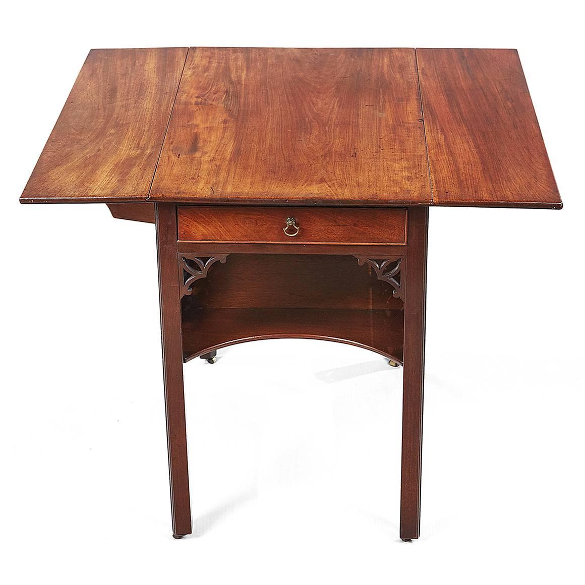 18th century Chippendale mahogany Pembroke table. The top with moulded edge and drop leaves raised above single frieze drawer with brass pull above concave lower shelf, intricate fretwork throughout, terminating on chamfered leg with brass