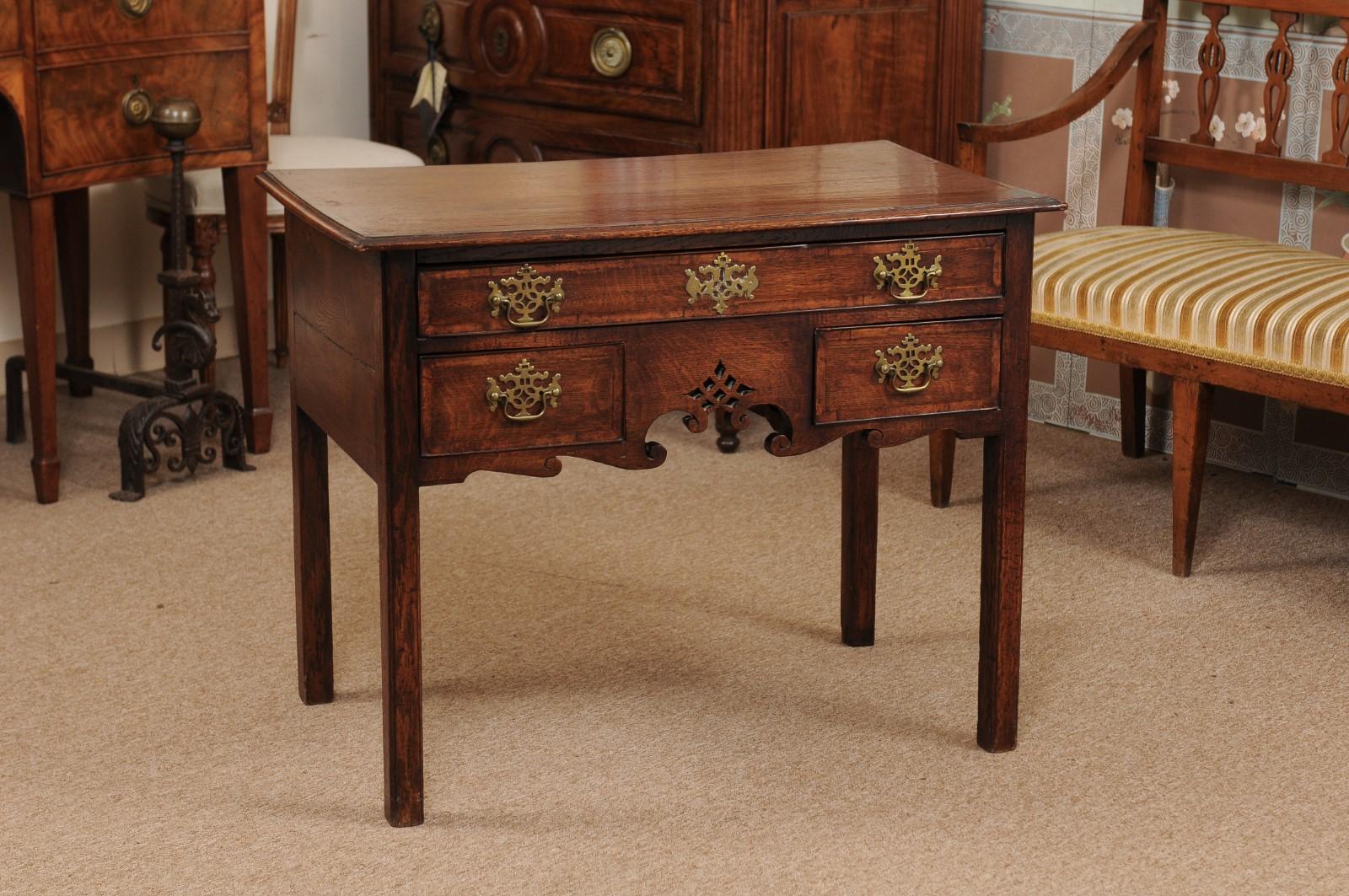 Chippendale oak low boy with 3-drawer configuration, crossbanding, and scroll detail on apron, England circa 1760.