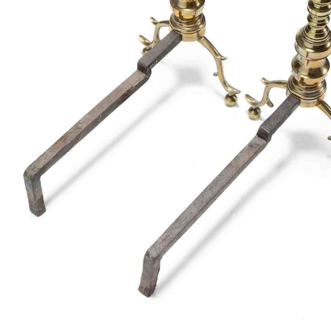 A uniquely handsome pair of Chippendale style brass andirons. Molded brass form with spur knee and ball feet.