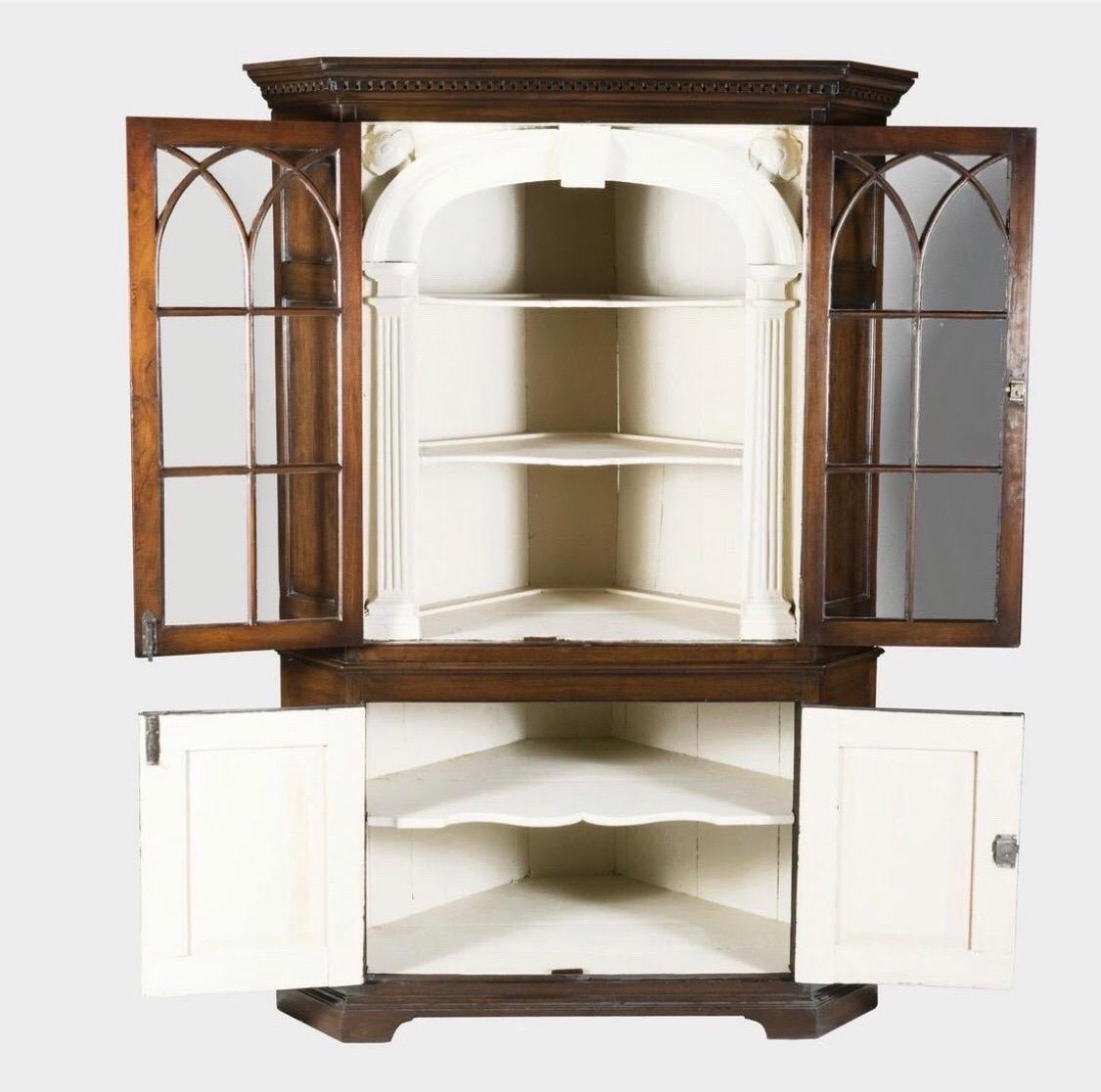 2 part cupboard consisting of 2 glazed doors over 2 paneled doors on the base. Dentil molding across the top, gothic arches in the glazed doors opening to 2 carved rosettes in the corners and 3 shelves. Creme painted interior. 



 