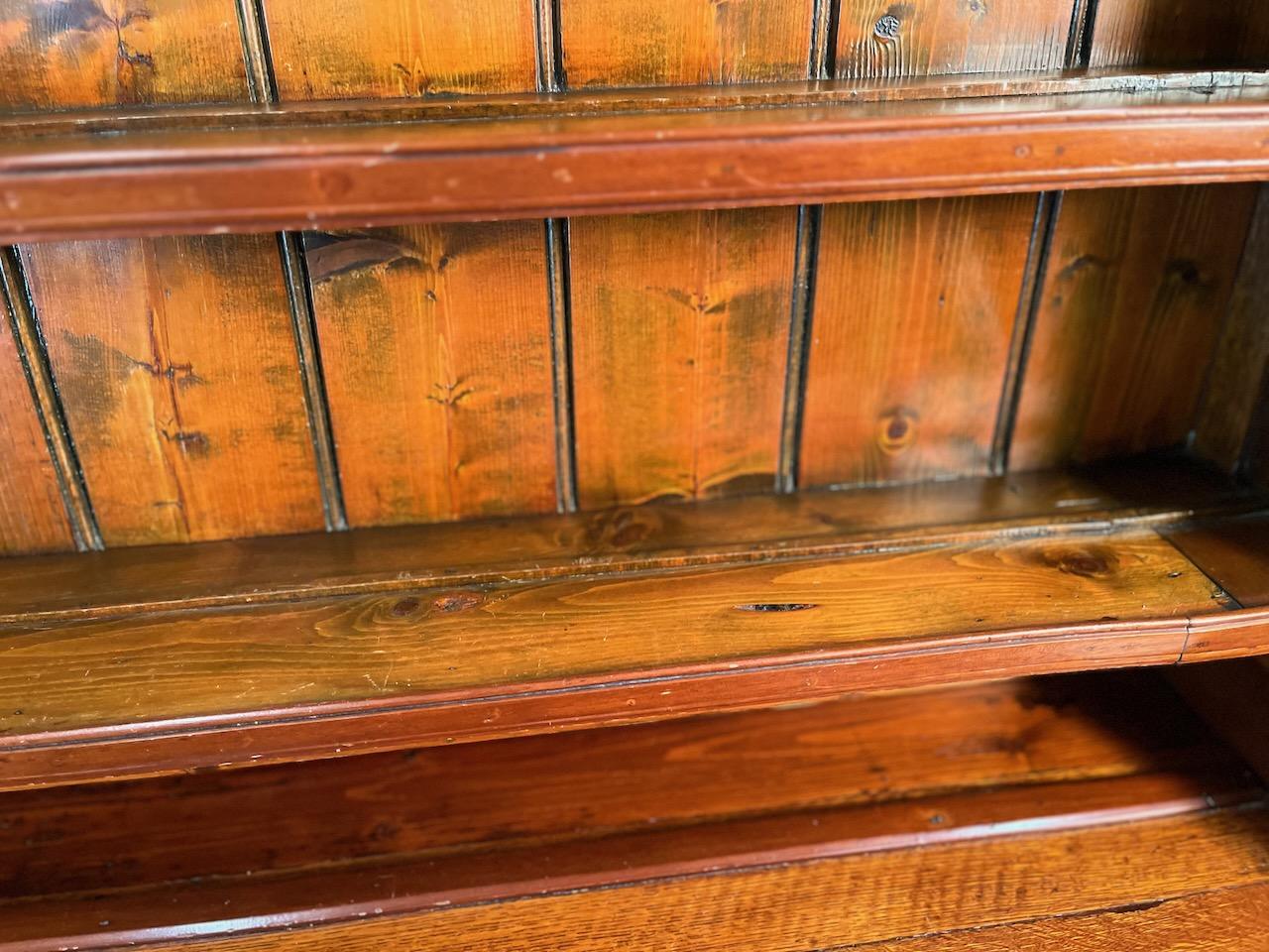 18th century classic Welsh dresser. Designed for kitchen or dining room display and storage with grooved open shelving above and six drawers and two cabinets below. Scalloped top and classic pilasters flanking the center drawer section below.  