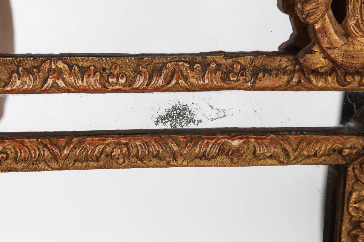 Continental style mirror with heavily carved gilded foliage and scrollwork throughout, circa late 18th century.
 