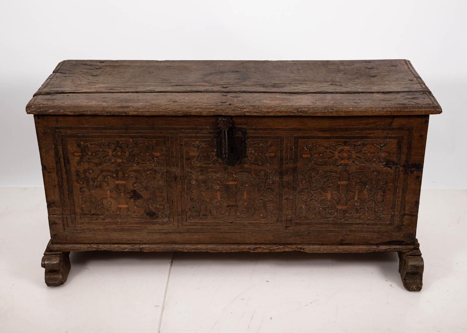 Continental style blanket chest in oakwood with carved geometric panels and metal hardware, circa 18th century. Please note of wear consistent with antique age including cracks, chips, and wood loss.