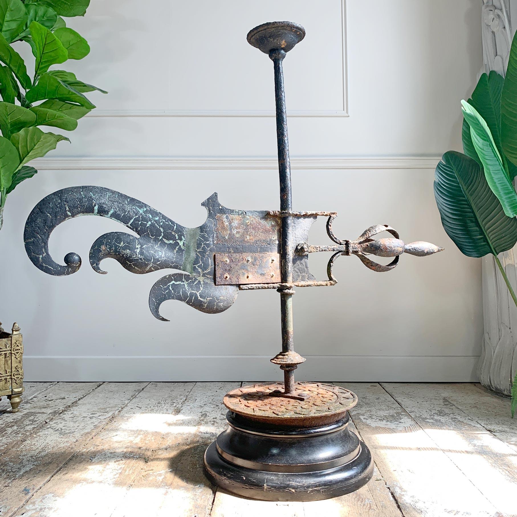 An incredible large estate made weather vane on a later base. Beautifully worn and with a wonderful patina, the vane features honest later repairs in copper to the centre, dating to circa 1790.

The base is a later enhancement, and the vane can be
