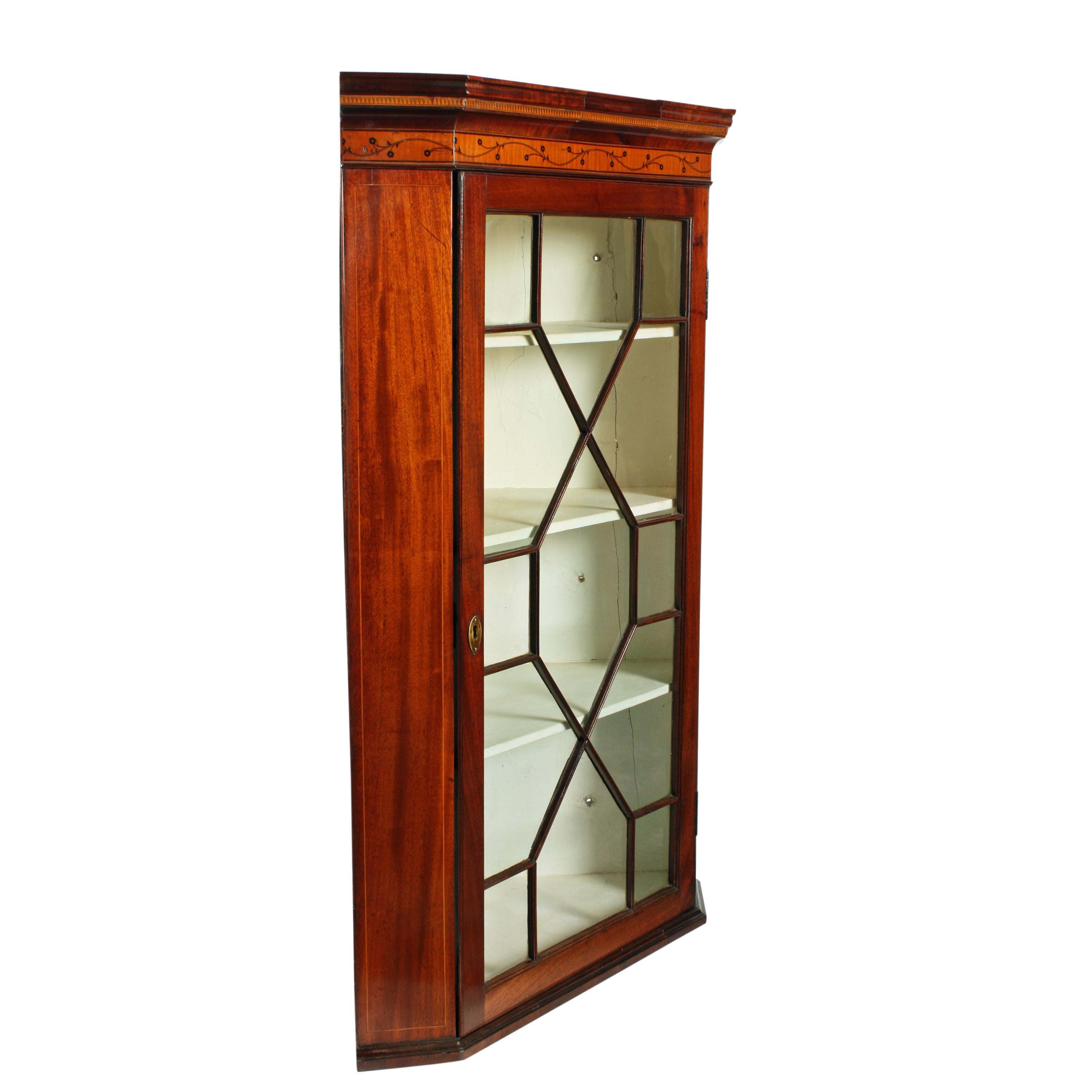An 18th century Georgian mahogany wall hanging corner cabinet.

The cabinet has a glazed door with thirteen panes of glass held in fine mahogany astragal bars.

The interior has three fixed shelves and has been re-painted in the past.

The cabinet