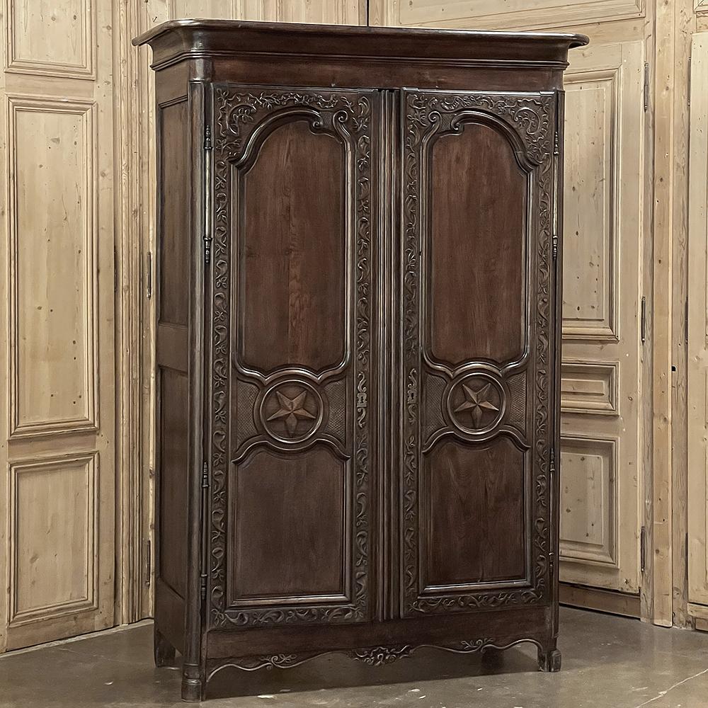 18th Century Country French Armoire with Carved Lone Stars on each door is a magnificent example of spectacular French craftsmanship, with hand-carved embellishment appearing from the crown to the base!  Stars representing good fortune appear at the
