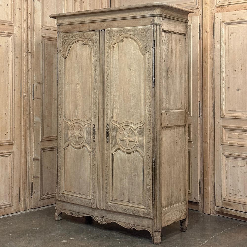 El Armario Francés Campestre del Siglo XVIII de roble decapado con estrellas solitarias talladas en cada puerta es un magnífico ejemplo de espectacular artesanía francesa, ¡con adornos tallados a mano que aparecen desde la corona hasta la base!  En