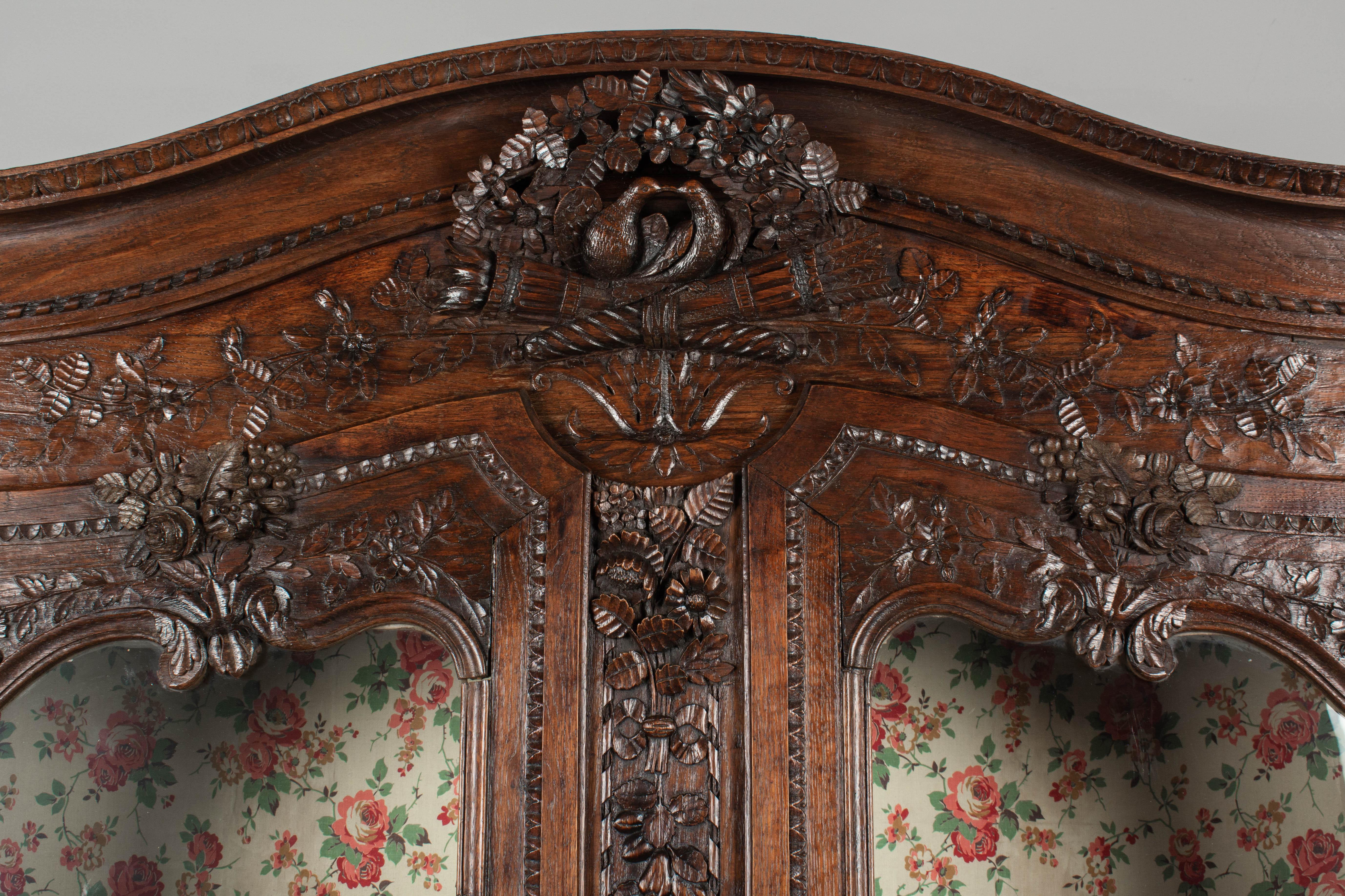 Buffet à deux corps normand de style Louis XV du XVIIIe siècle, en chêne massif sculpté à la main. Il s'agit d'un cadeau de mariage traditionnel, apporté par le marié à sa nouvelle maison, qui comporte de nombreux motifs romantiques. Les sculptures