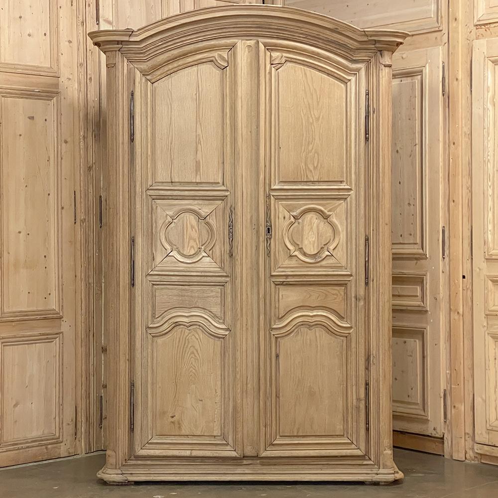 18th Century Country French Louis XIII armoire in stripped oak will make an impressive and stately presence in any room! The boldly molded arched cornice, called a chapeau de gendarme in France due to its resemblance to the official hats worn by