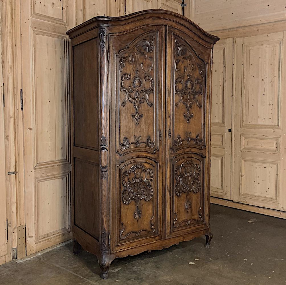 18th century Country French Louis XV armoire is an unusual example, featuring finely carved solid wood door panels rather than the more typical mirrored door. This combined with the outboard-mounted hinges makes it a great choice for any room,