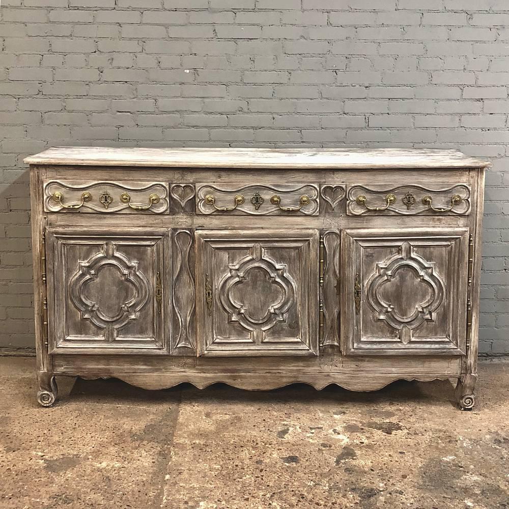 Completely handcrafted in the days before mechanization, this handsome and rare 18th Century Country French Normandy Stripped Oak Buffet appears to have a tailored look but that belies the intricacies of the artisanry that was required in its