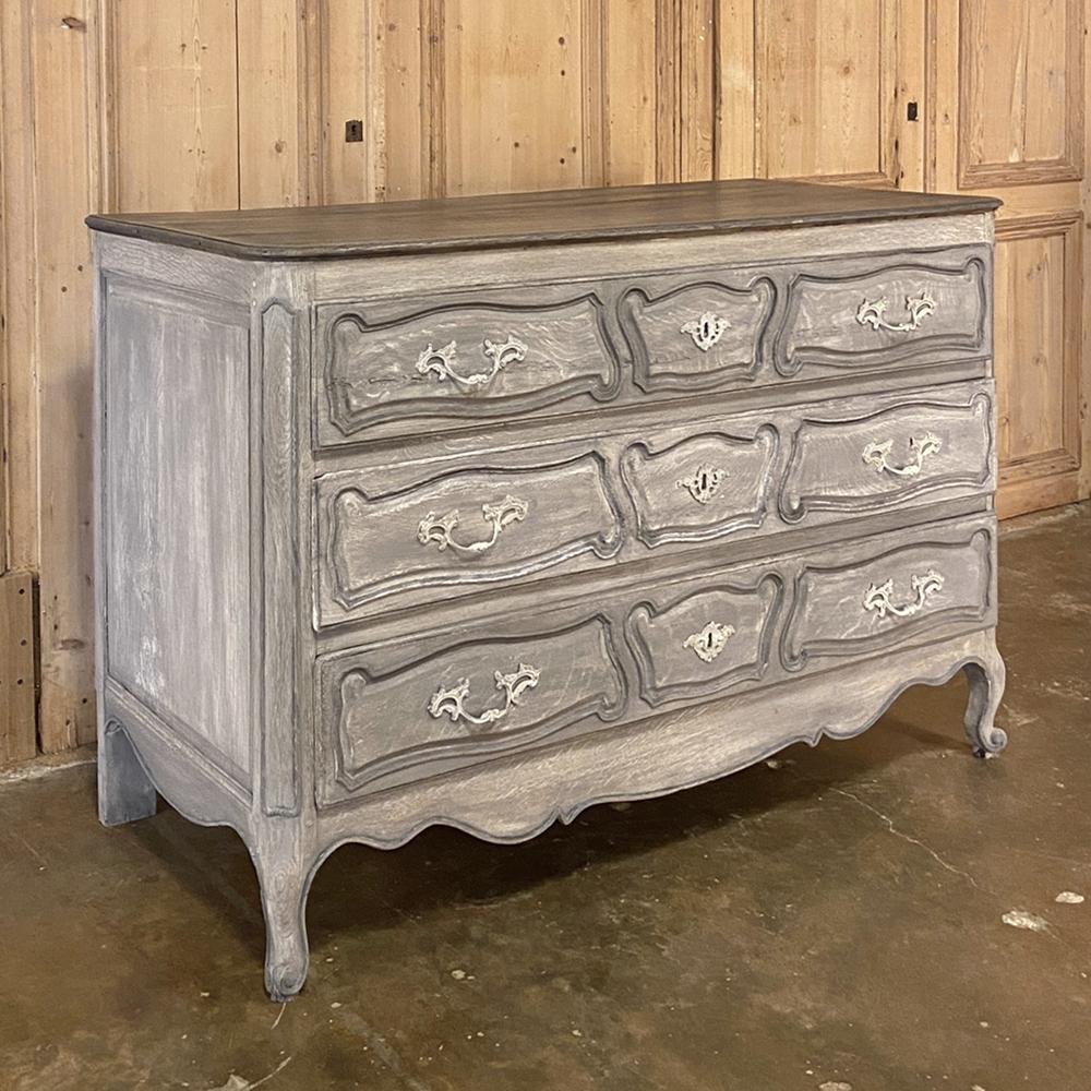 18th century Country French painted commode represents the essence of the genre, with tailored lines and visually appealing scrollwork across the entire facade. The undulating apron with scrolled legs appears below the three abundantly spacious