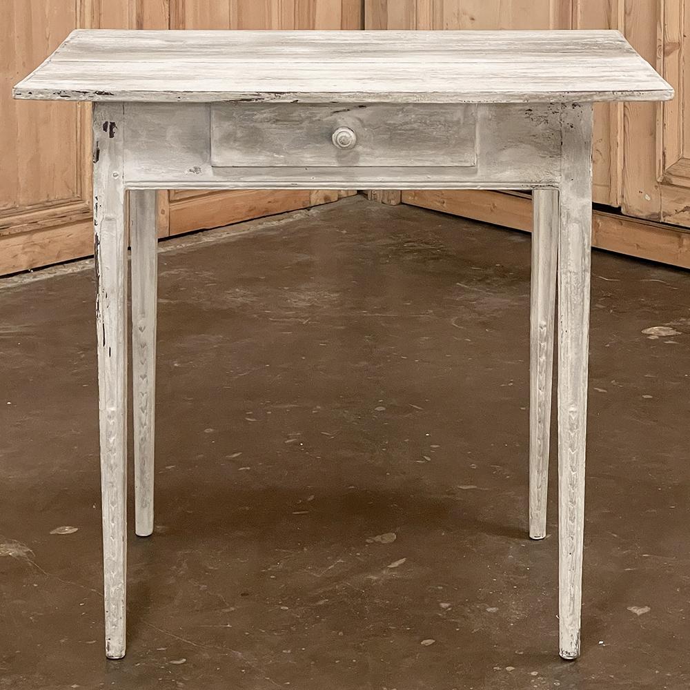 La mesa auxiliar pintada a la francesa del siglo XVIII presenta líneas entalladas hechas con tablones y postes macizos de roble viejo, con un pequeño detalle tallado en las patas cónicas para darle interés visual. Un único cajón proporciona un