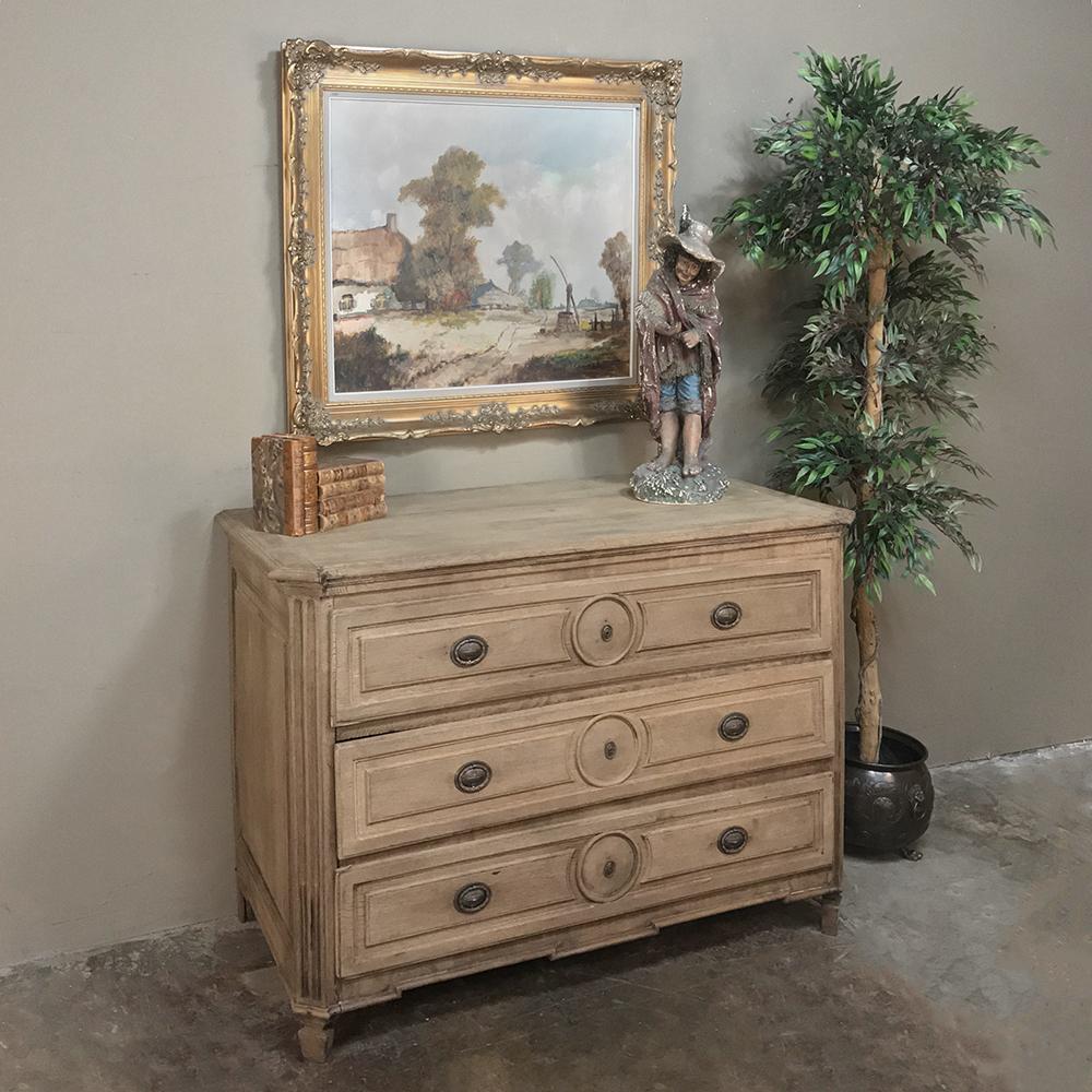 18th century French Provincial Louis XVI stripped oak commode was a period effort by talented rural artisans to reflect the styles currently in vogue at the king's court. The return to classicism brought back tailored rectilinear architecture and