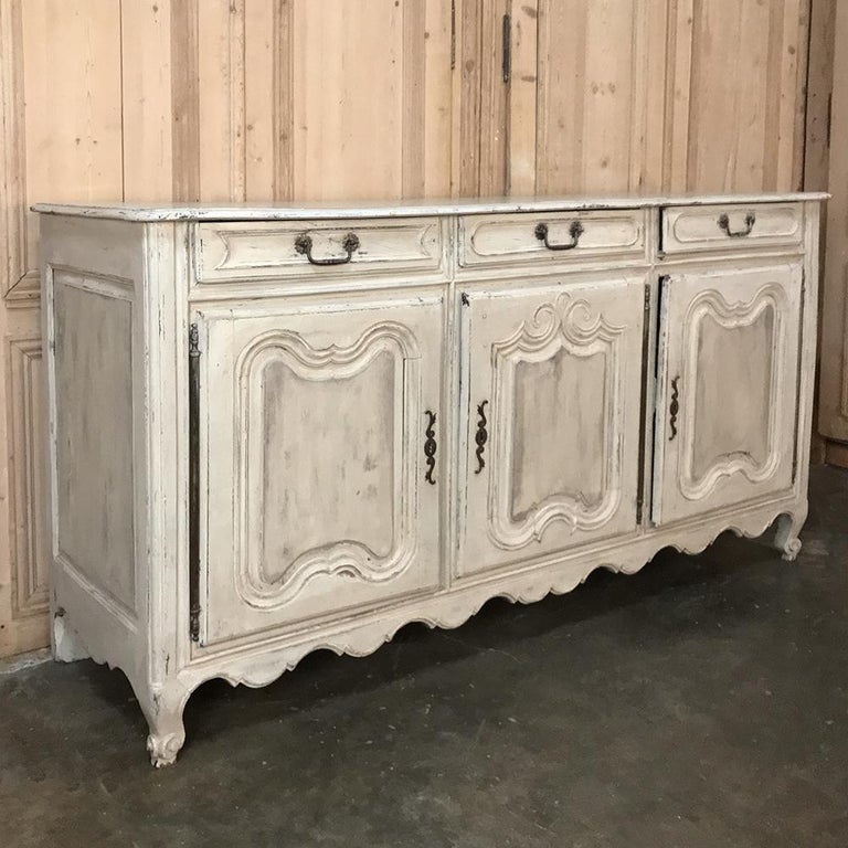 18th century Country French Provincial painted buffet is perfect for adding a casual and whimsical touch to your decor. Tailored molding around the scrolled panels combine with the undulating apron and steel pulls and key guards to create an