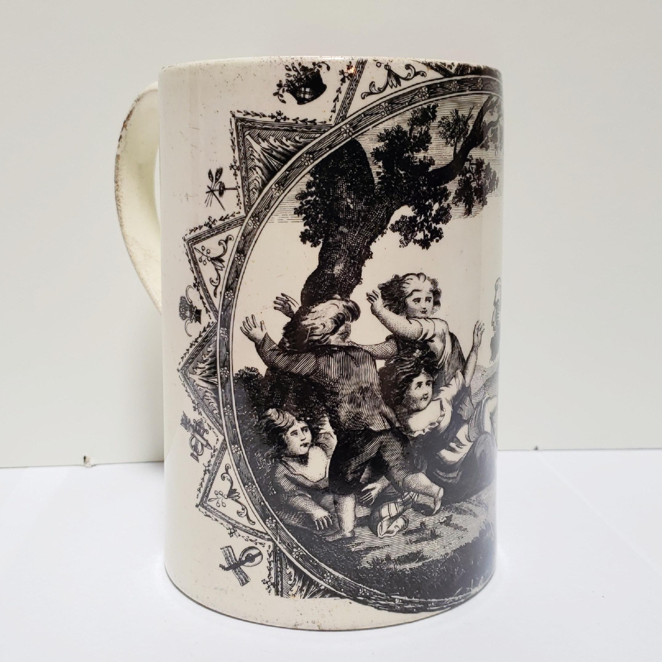A pottery creamware handled mug with a black transfer printed framed picture of children being frightened by demonic mask. The majority of these late 18th century creamware pieces are attributed to potteries in and around Liverpool, England. This