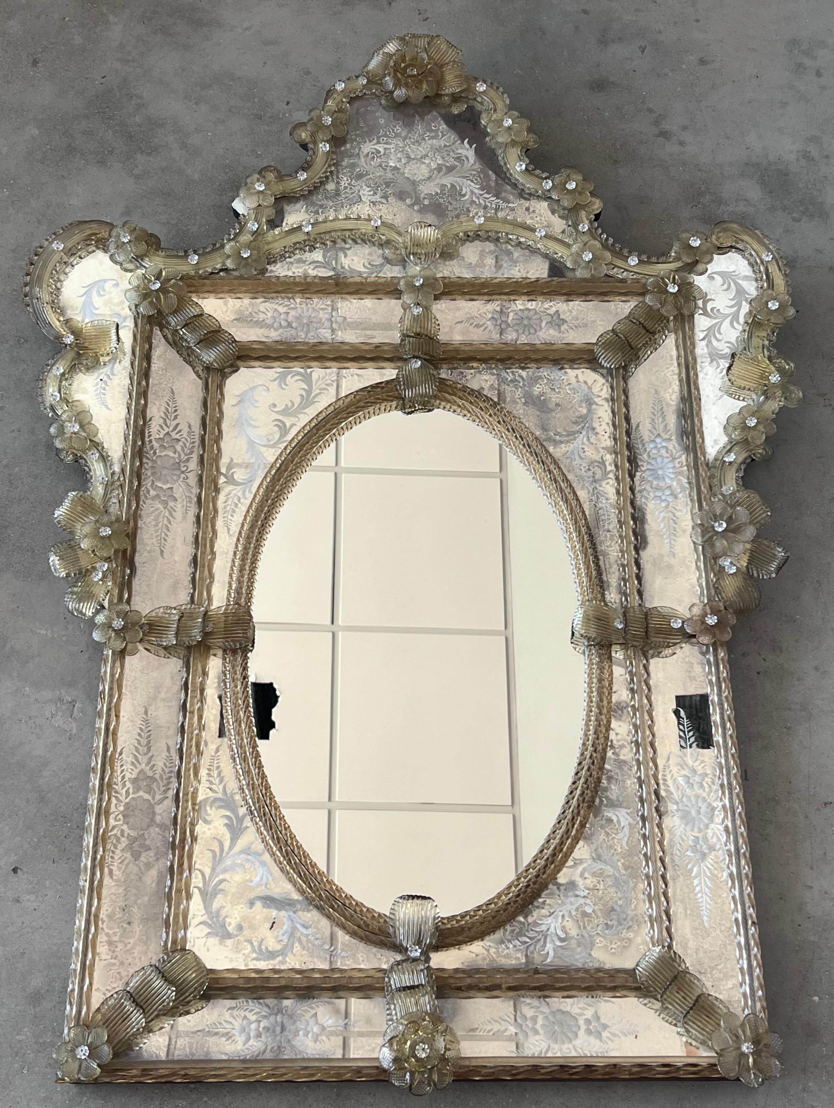 The crest top Venetian mirror. With its beveled panels and carved crest topped with a lovely lotus flower-like motif, the crest top mirror has been handmade and hand silvered. The central panel shows a light antiquing finish while the surround has a