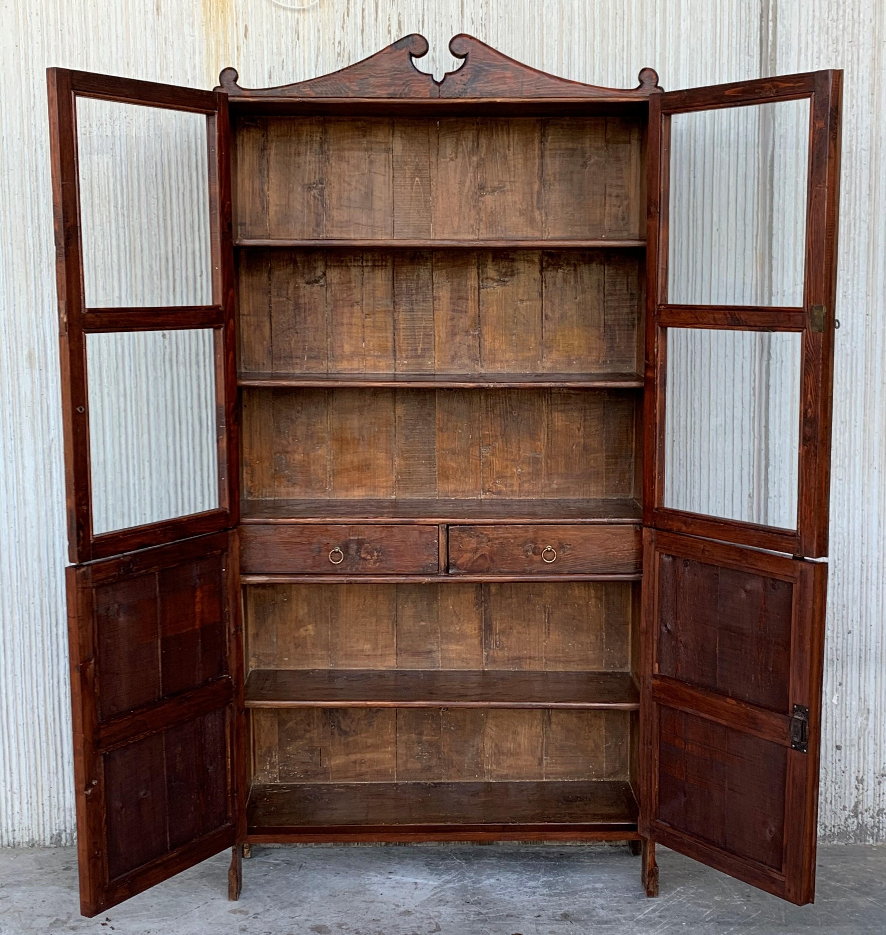 Exquisite 18th century Spanish cupboard or bookcase with glass vitrine, constructed from walnut and original glasses of this period. Features a coffered case fronted by four large doors. It has a two drawers in the low part. This massive cabinet