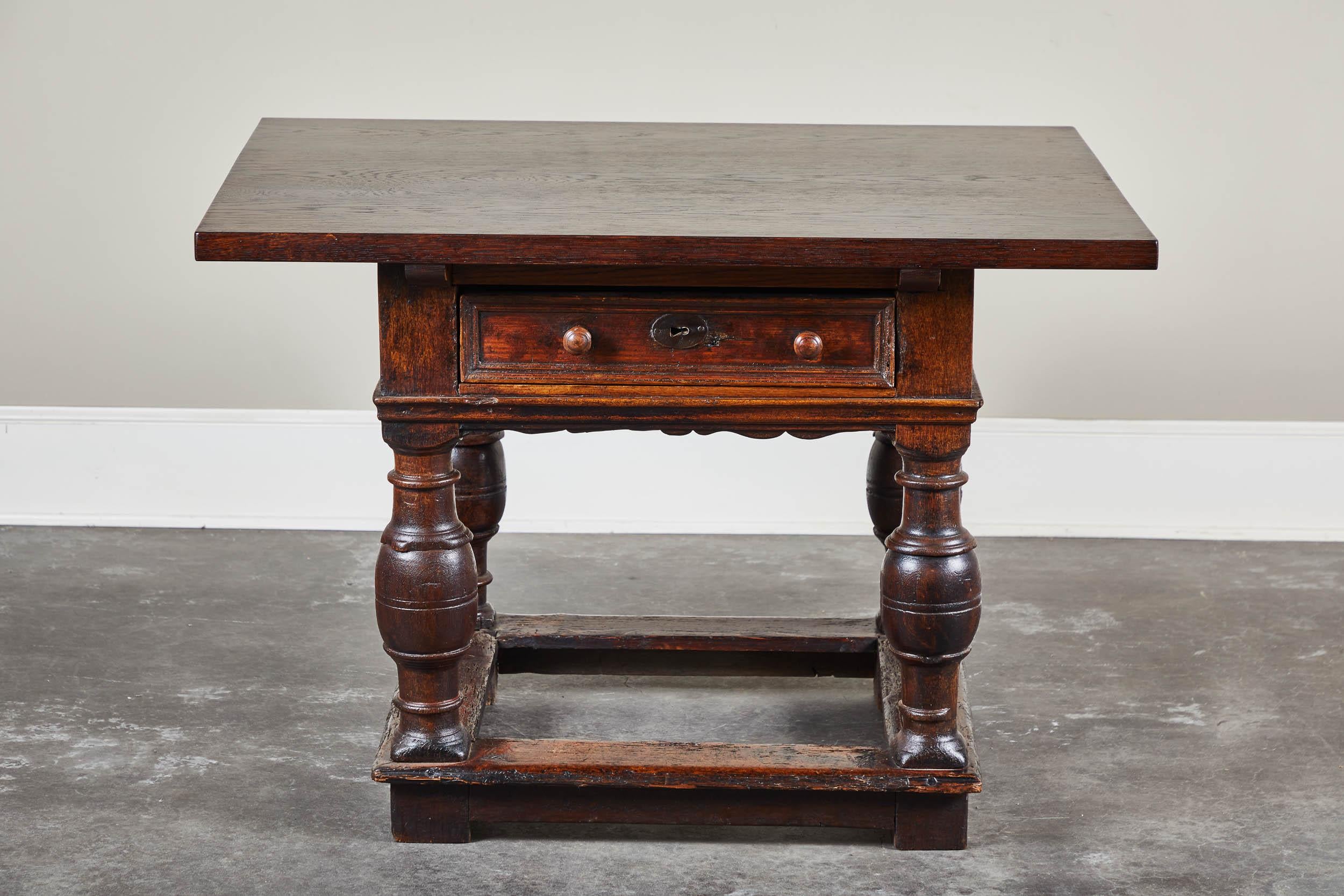 An 18th century Danish Baroque style table featuring one drawer with two handles and interesting turned legs. The table consists of a newer top.