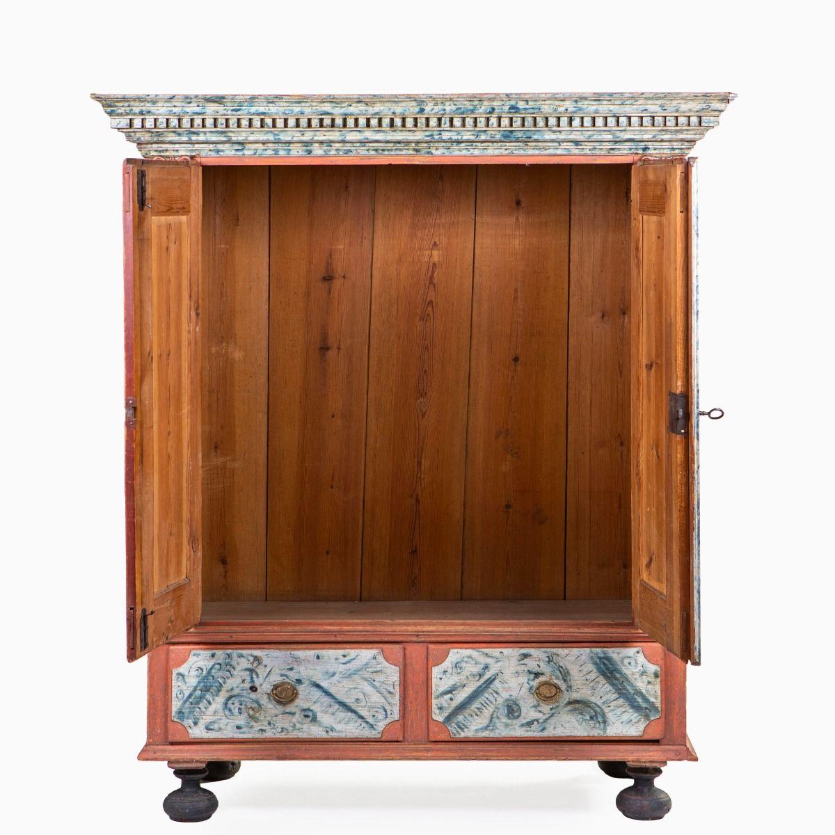 Decorative and rare Louis XVI / Gustavian cabinet with original paintwork.
This striking Danish cabinet, dated circa 1790–1800, features a coral red base with two doors decorated with beautifully preserved blue-grey faux marble panels. Below, a pair