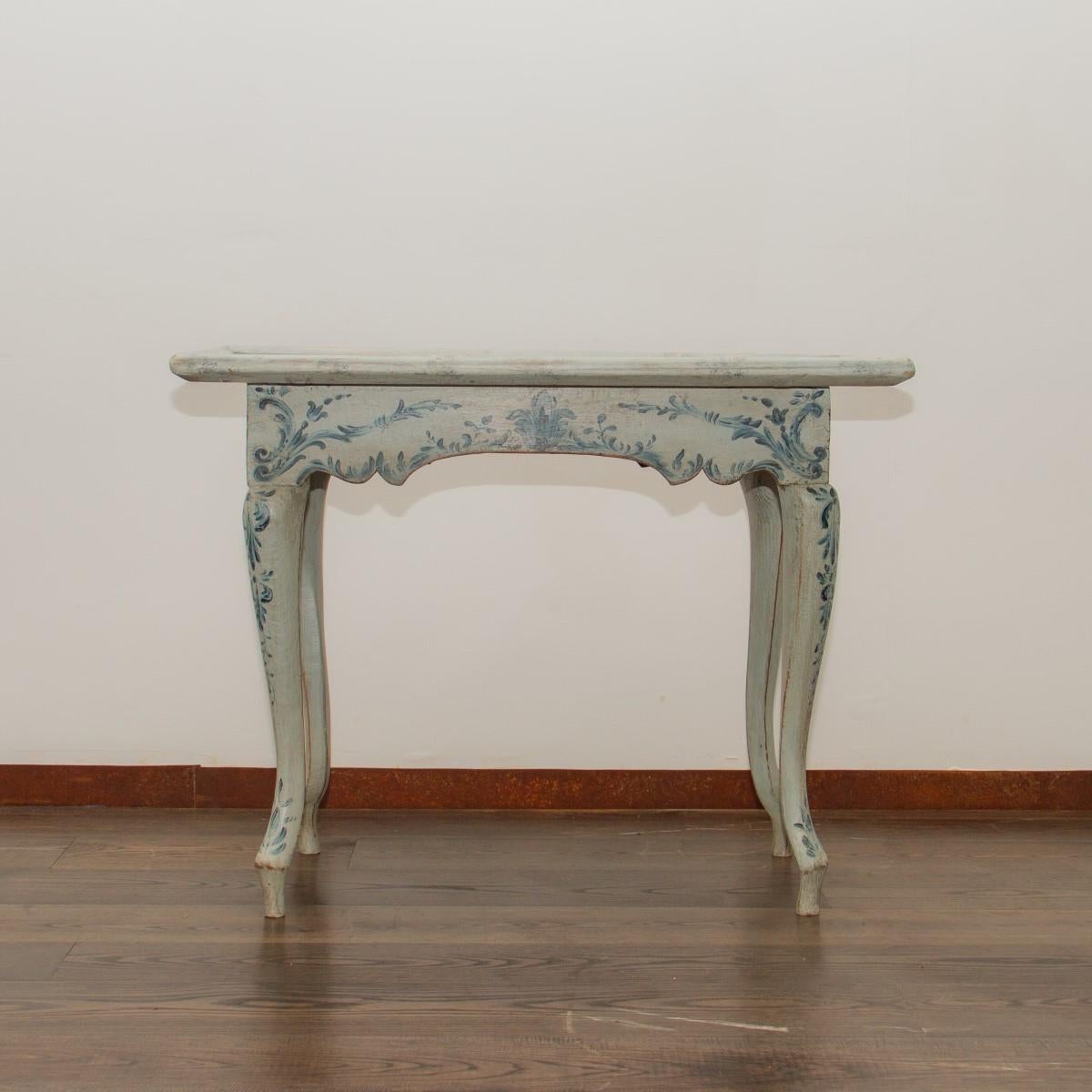 A mid-18th century Danish white painted table with painted blue floral designs under the tabletop and down the cabriole legs. The tabletop is made of planks which are then framed to create a tray like top, which has then been painted to simulate