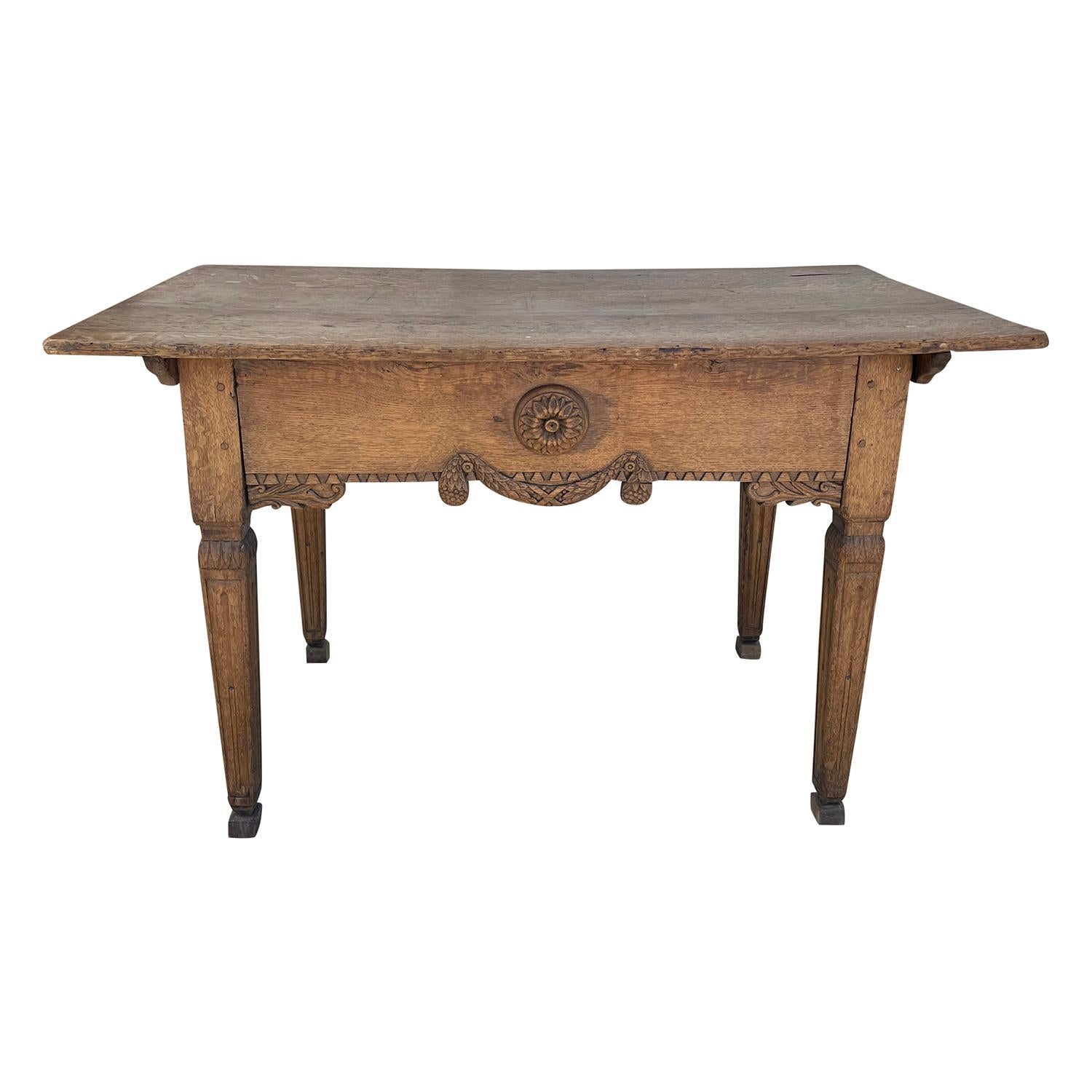 An antique French Régence console, farm table with an apron, made of hand crafted Oakwood in good condition. The end, side table has four straight, tapered wooden legs, enhanced by detailed wood carvings. The table is consisting its original metal