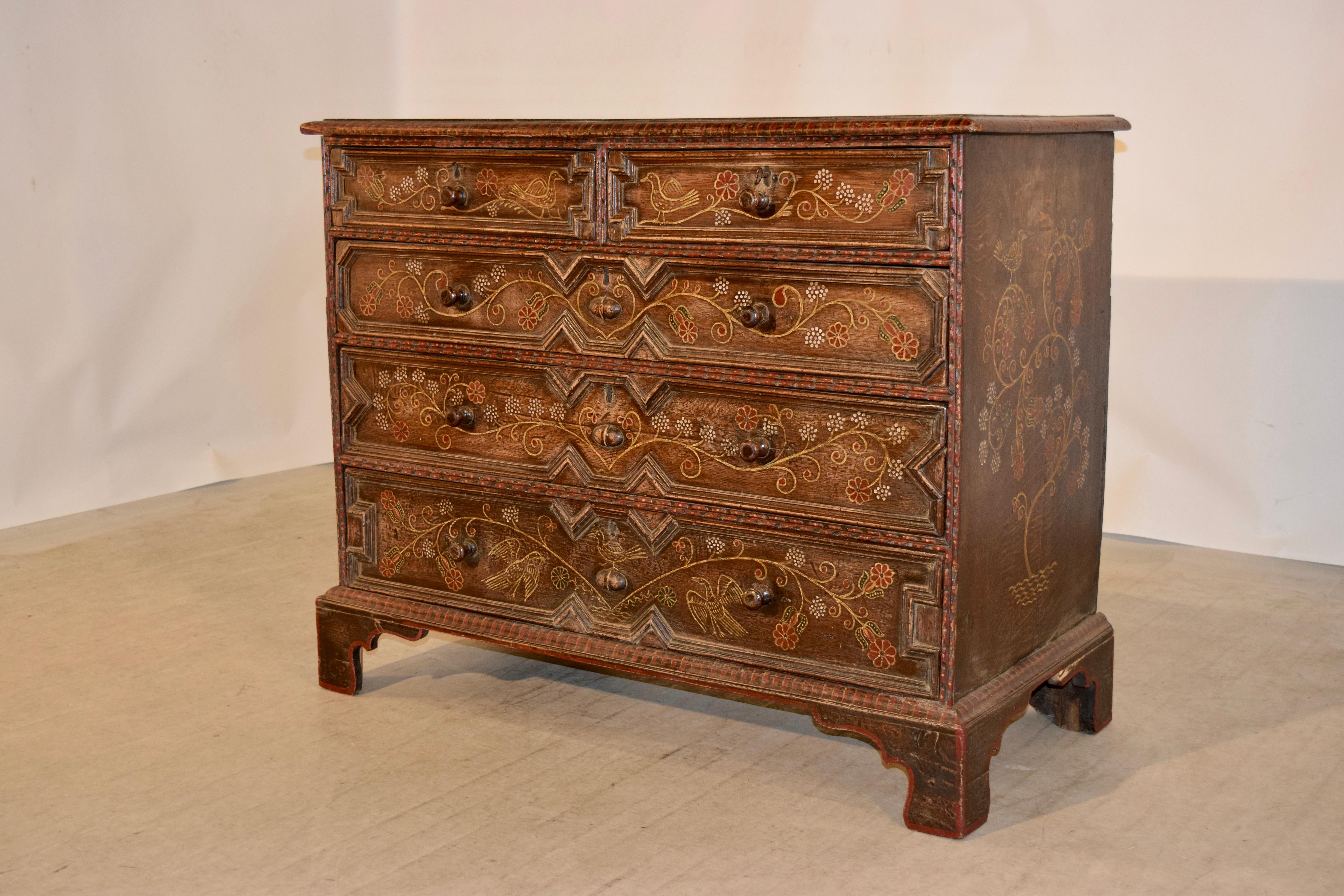 Mid-18th century decorated oak chest from England. The top is made of two planks and has a bevelled edge following down to simple sides and two smaller drawers over three larger drawers, all with geometric raised drawer fronts and supported on
