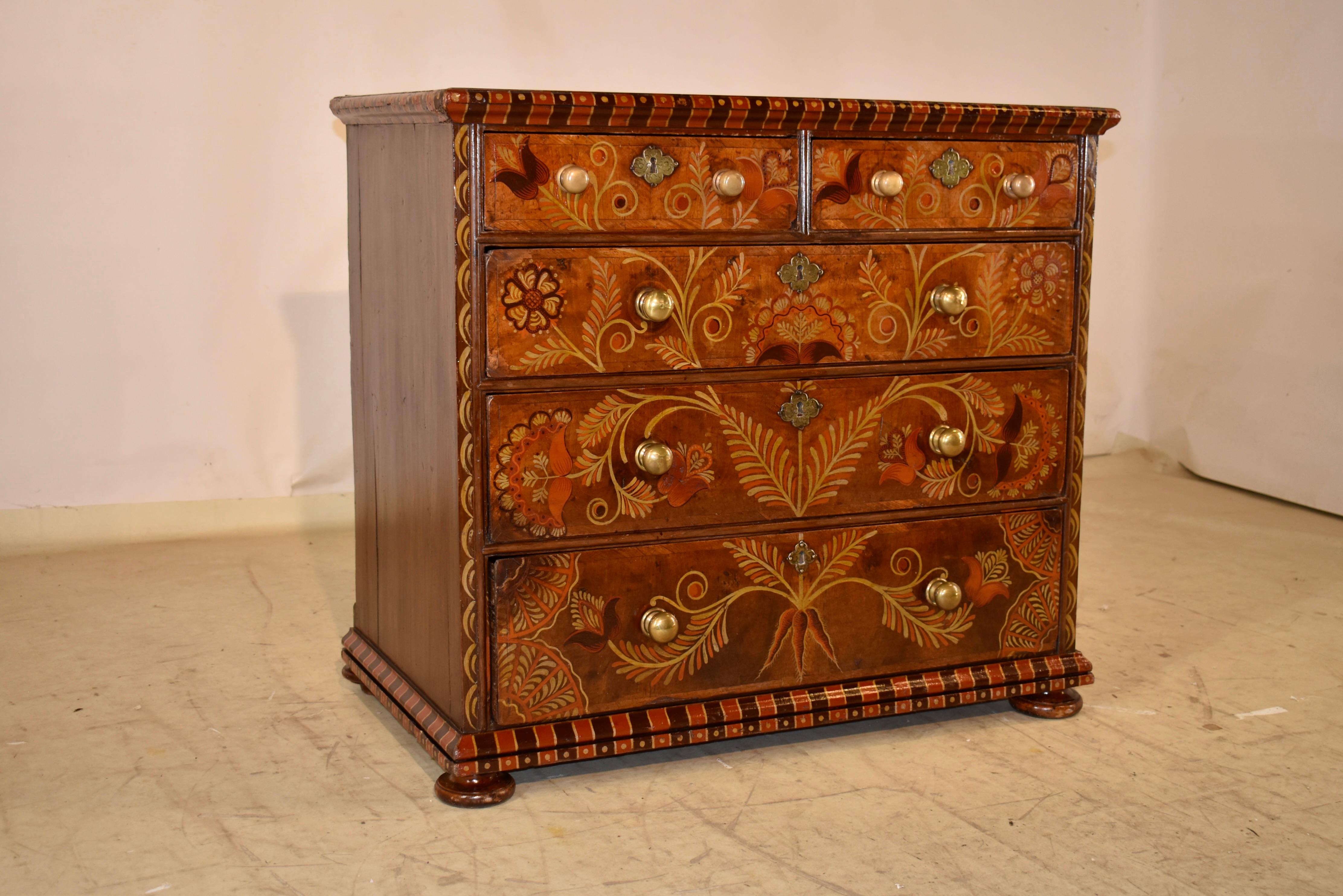 Cassettiera in noce decorata dell'inizio del XVIII secolo proveniente dall'Inghilterra. Il piano è composto da due assi e presenta una splendida fascia intorno al bordo del cassettone che termina con bordi smussati e modanati.  Segue una struttura