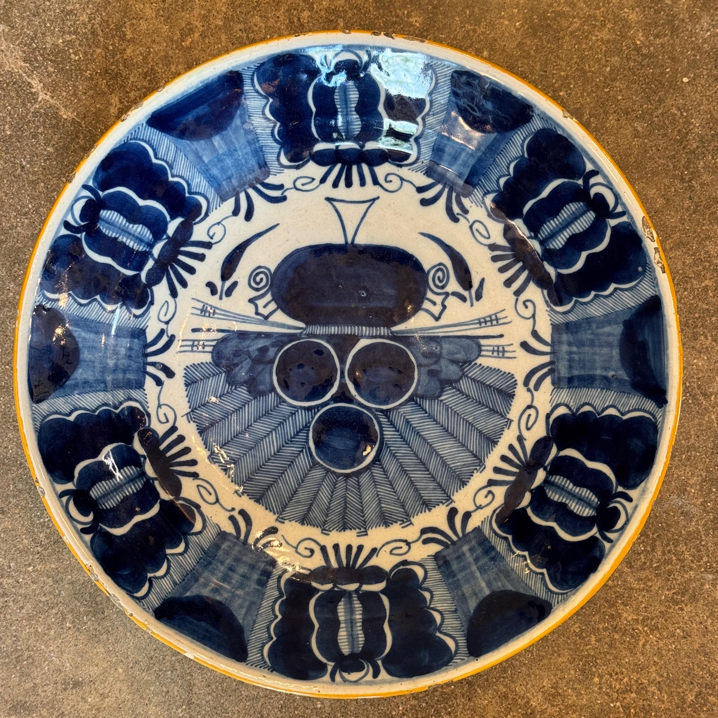 An 18th century Delft charger hand-decorated in bold cobalt blue with a variation of the “Peacock” pattern. This version features a more abstracted central motif with radiating feathers and stylized florals around the rim. The heavy brushwork and
