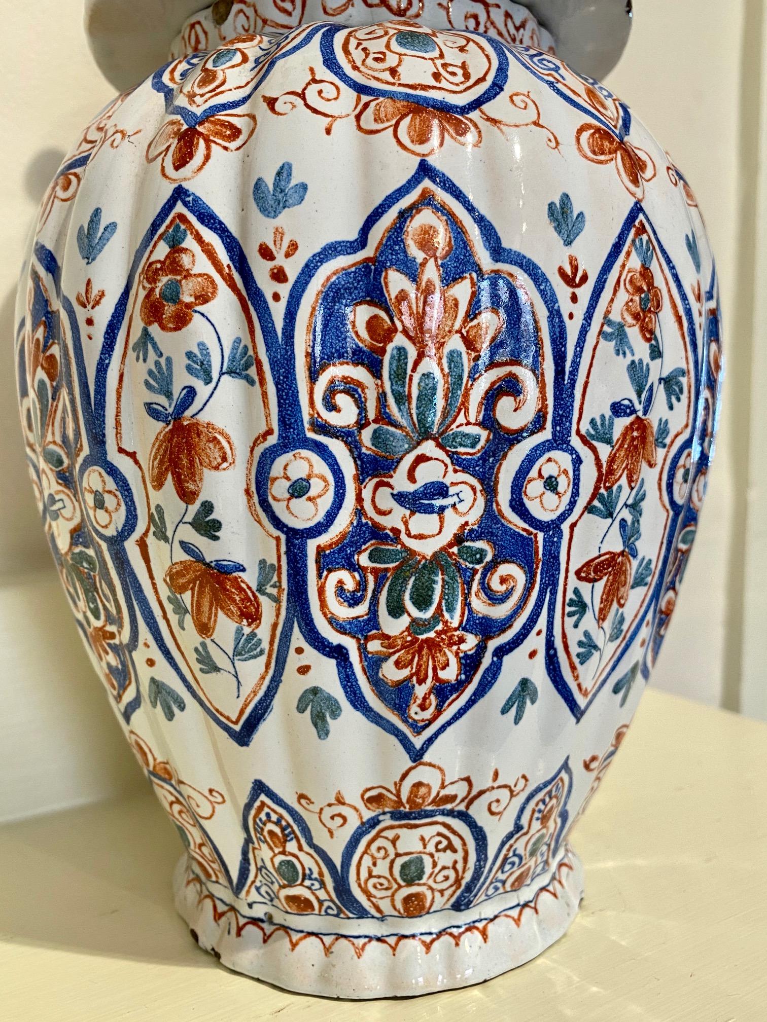 Antique Dutch Delft pottery covered urn, mid-18th century, a tin glazed earthenware vessel having a dog finial atop a domed lid, on a ribbed ovoid body, decorated in a blue and red Oriental design, signed with a D AP W monogram on the bottom which I