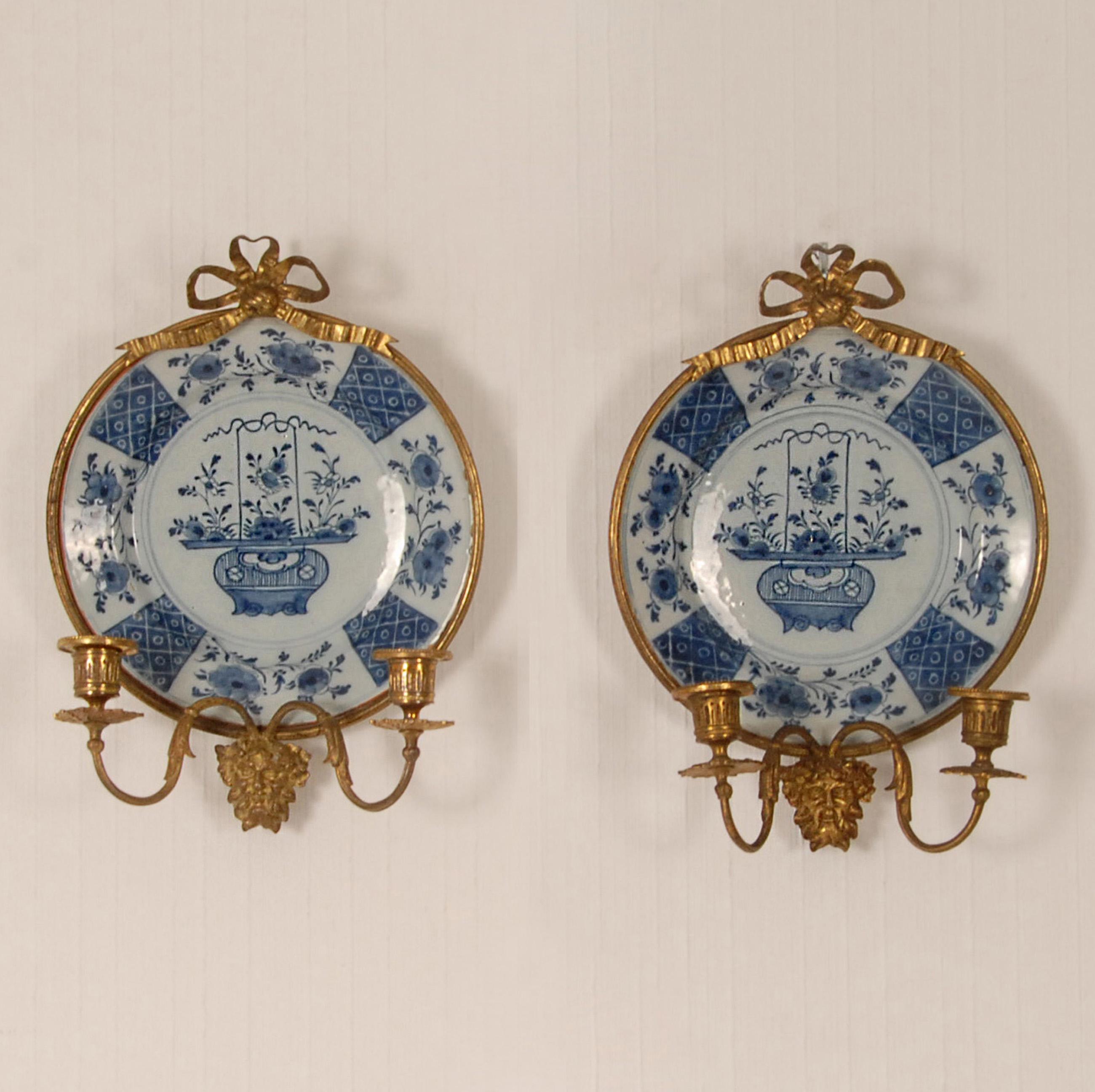 A pair Dutch Delftware Royal Delft bronze mounted wall sconces candelabra wall plates
Decorative Delft plates mounted in gilt bronze with on top a ribbon and
a faun mask with 2 candleholders
The plates are hand crafted and hand painted in enchanting