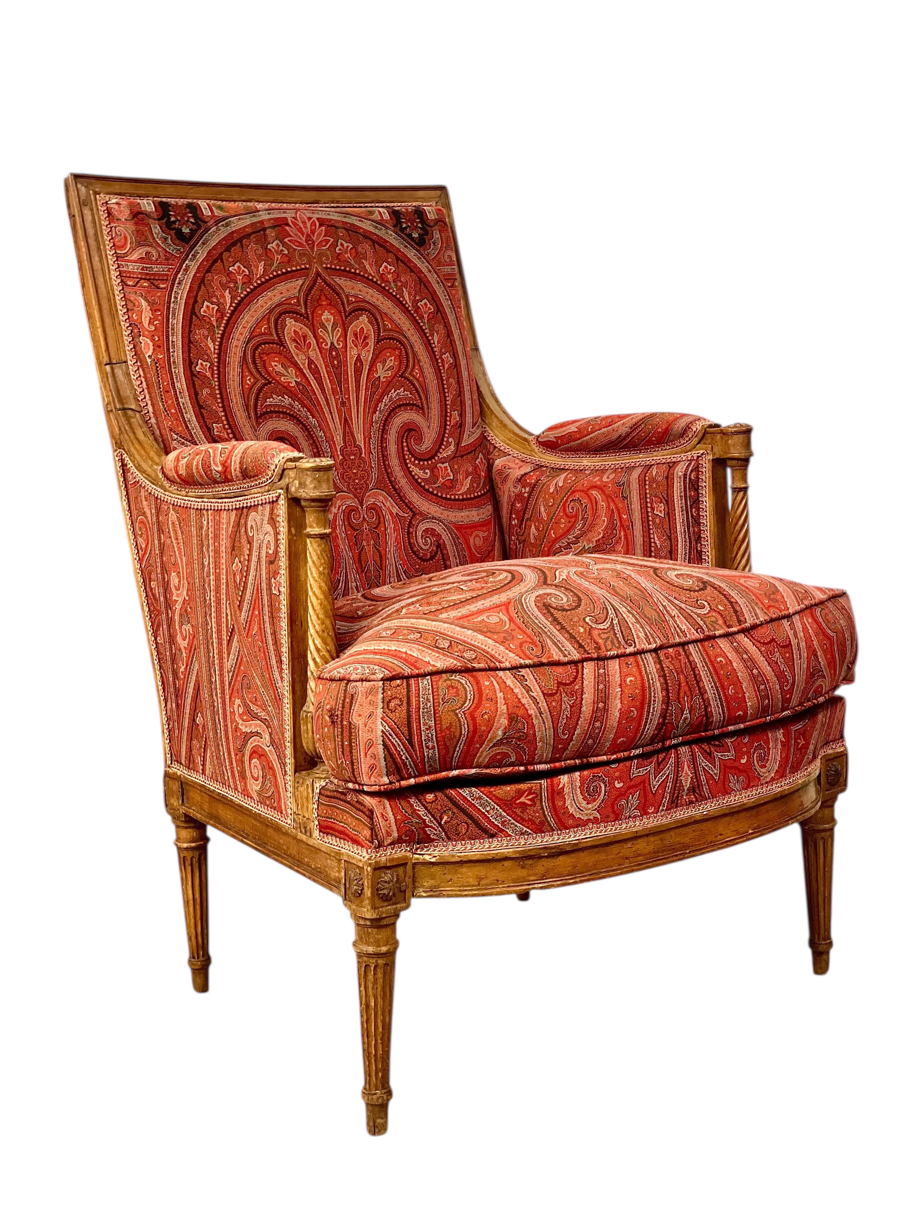 Esta rara bergère francesa data de finales del siglo XVIII, durante el elegante periodo de transición entre los estilos Luis XVI y Directoire. Fabricado en madera de haya maciza, el armazón exhibe una artesanía excepcional, con rosetas florales